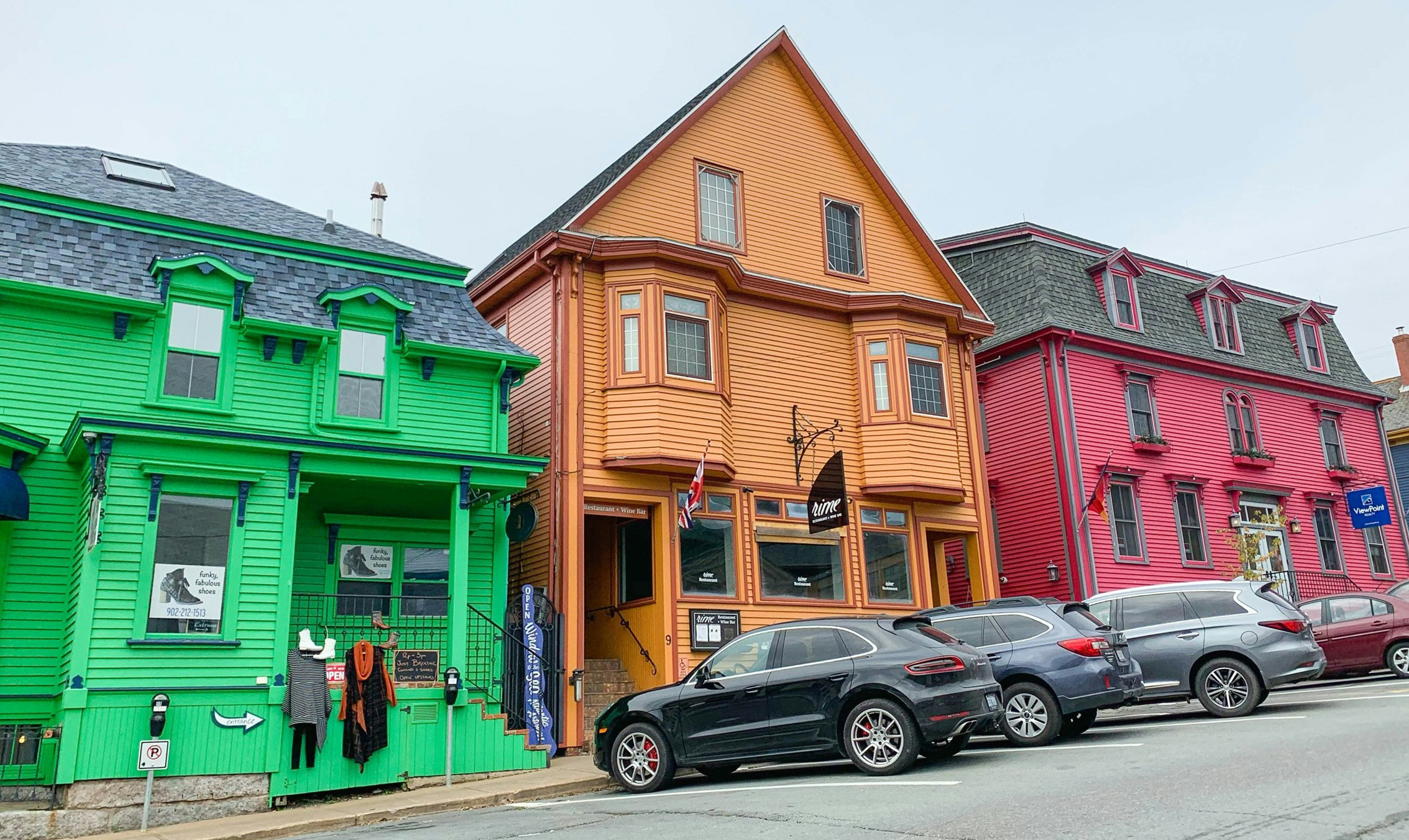 A green, orange and red building are seen on a hill in Lunenberg, Nova Scotia