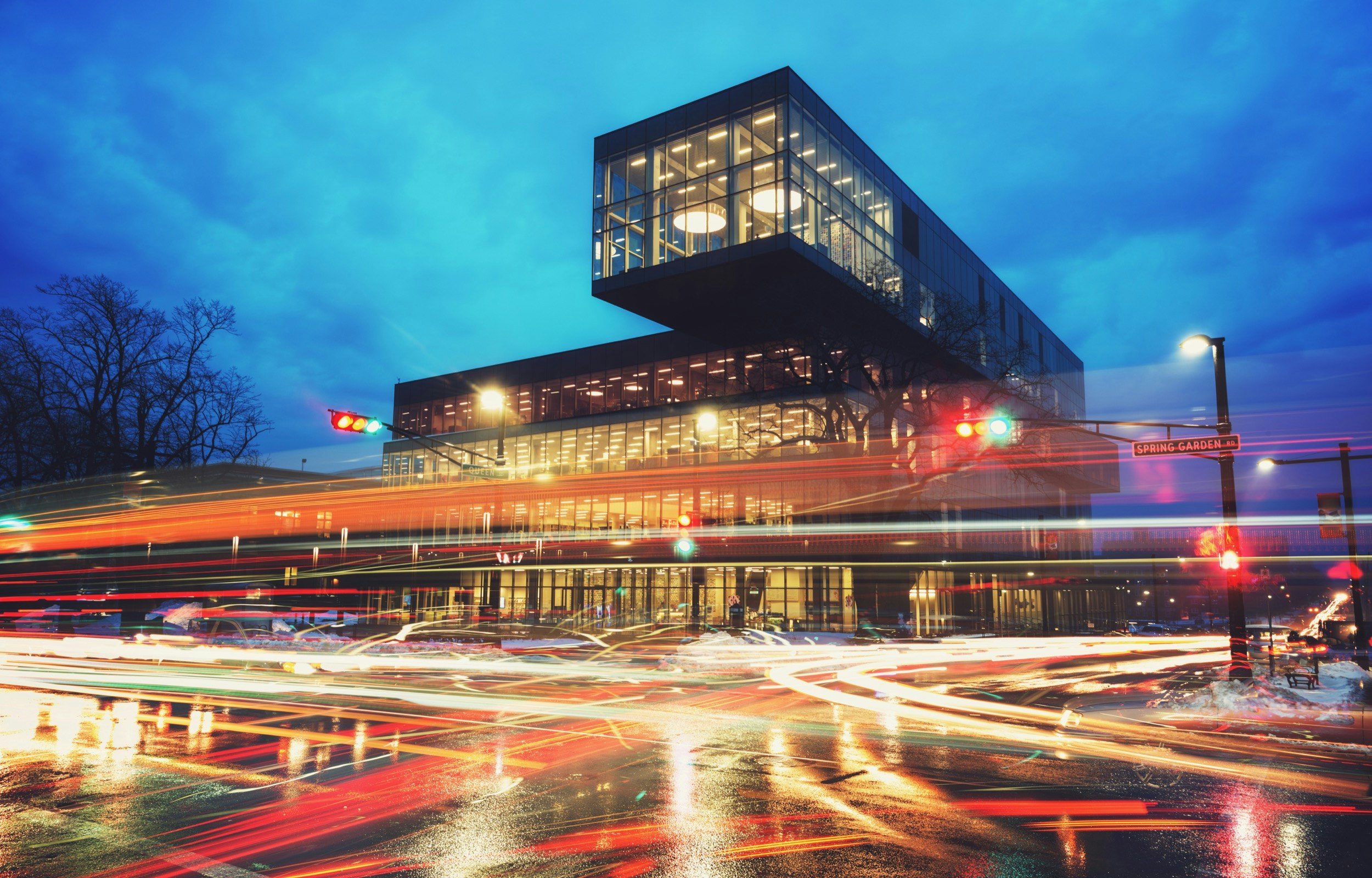 Motion blur is applied to the lights of cars as they drive around the Halifax Central Library as dusk turns to night