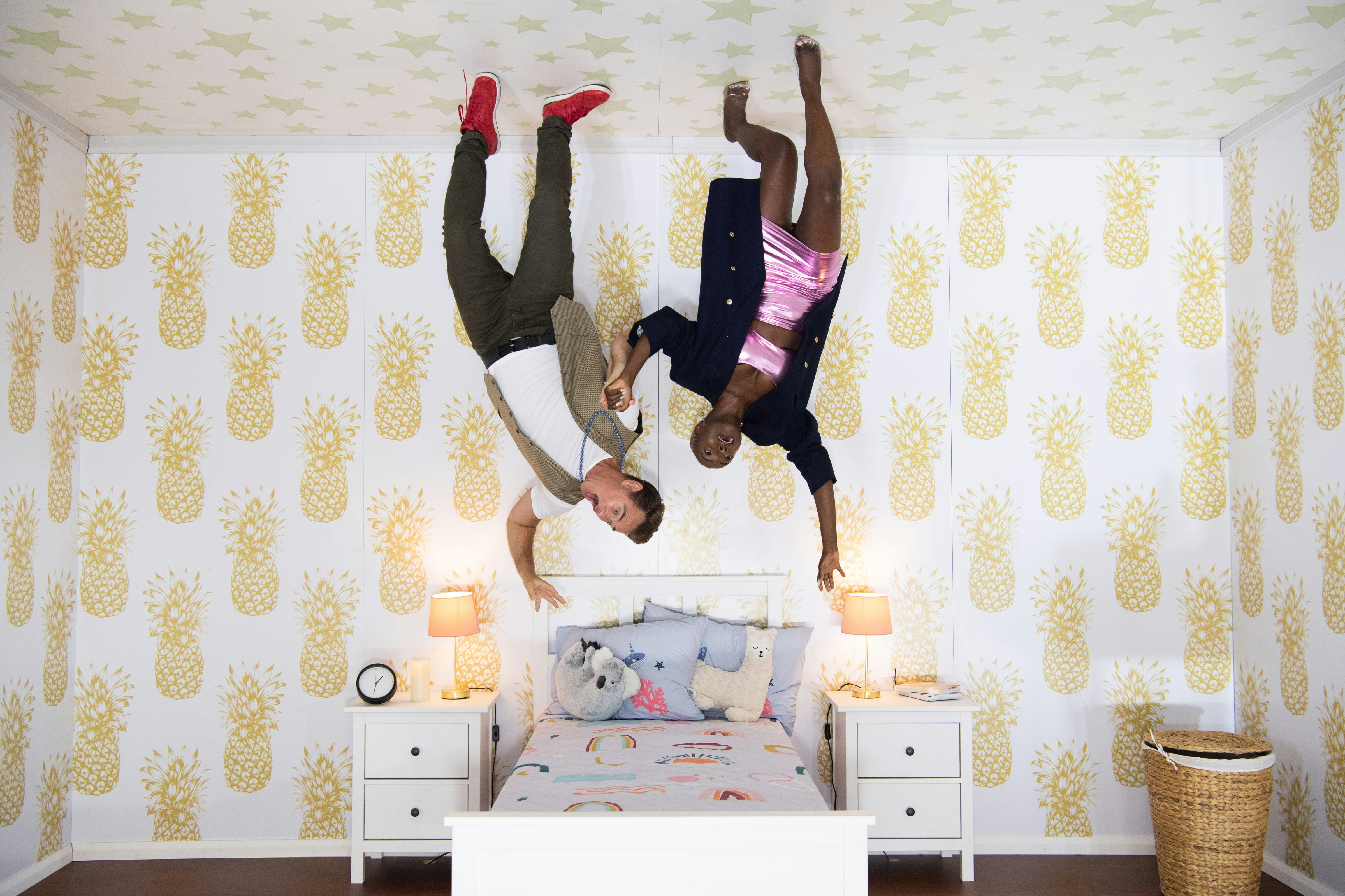 Visitors play in an 'upside-down bedroom' at an exhibit in Sydney