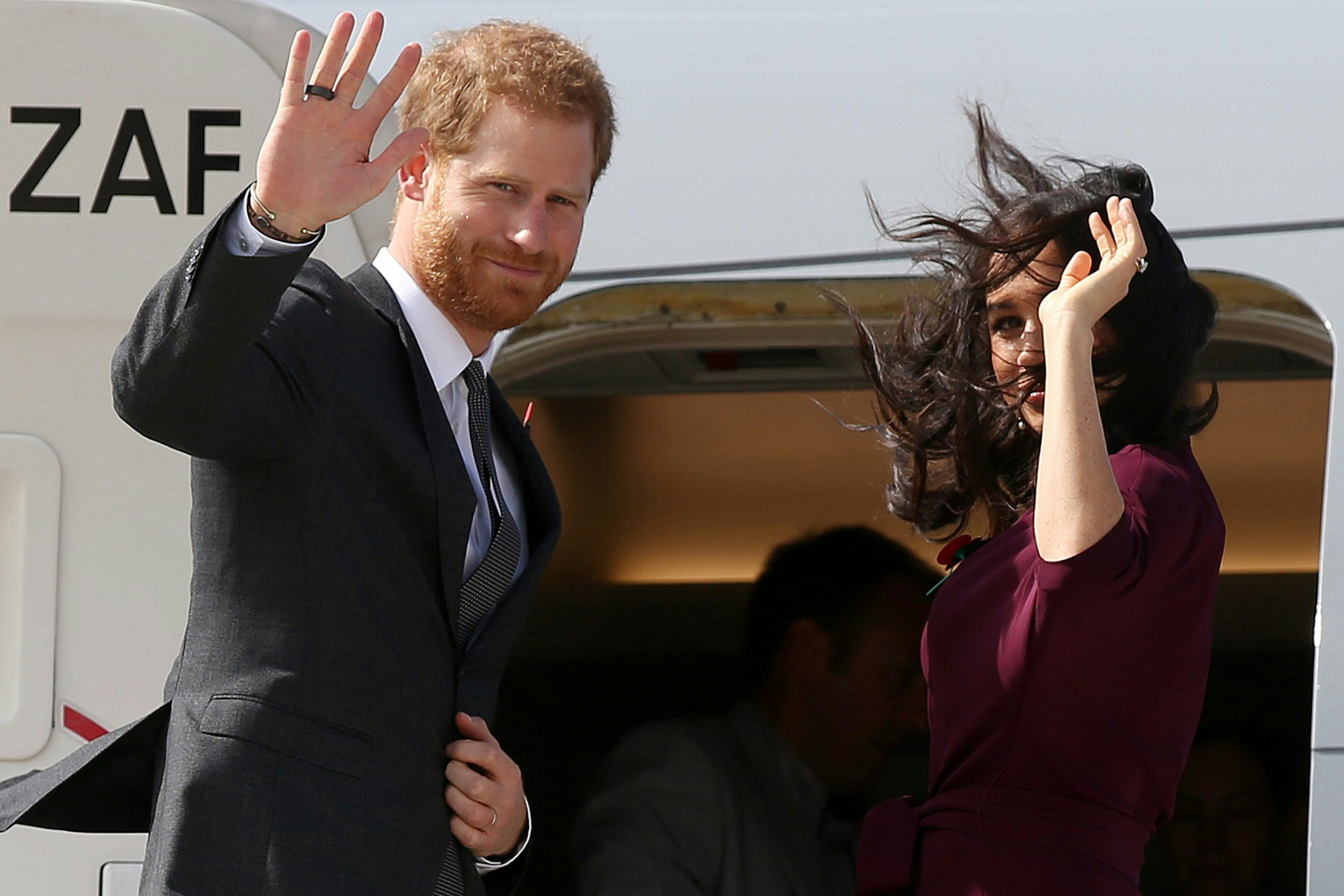 Harry and Meghan boarding a place