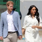 Prince Harry and Meghan Markle olds hands while visiting a Youth Employment Service building in South Africa.