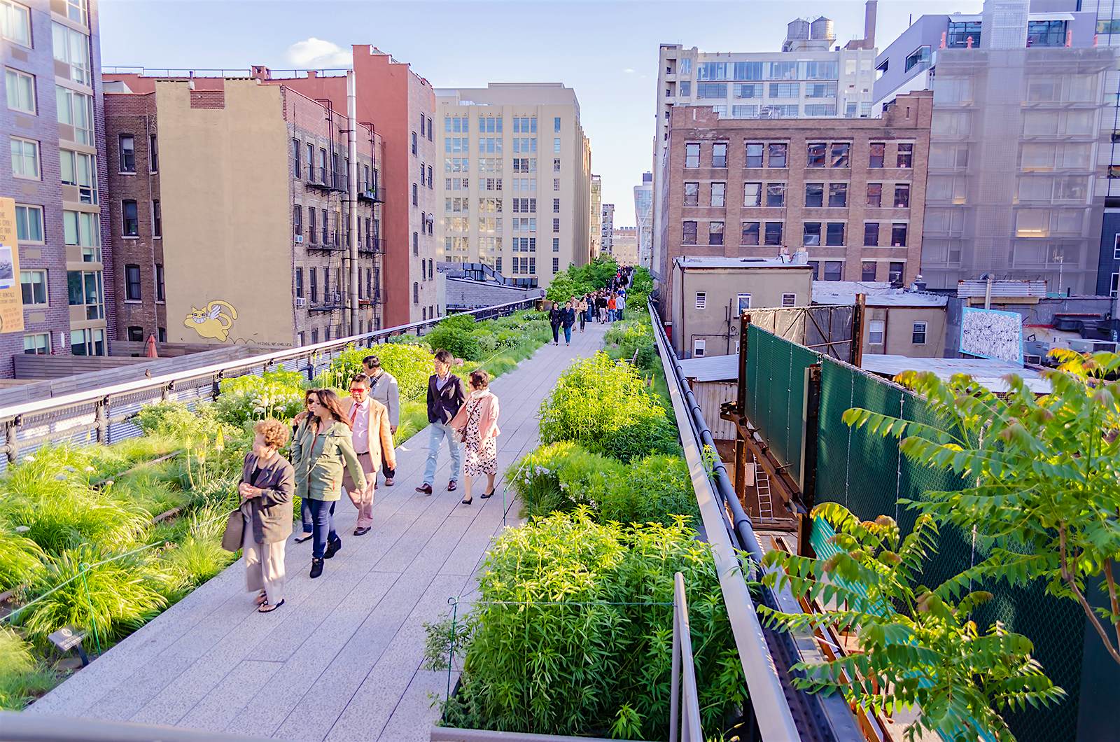 High Line - free things NYC.jpg A group of people walk across the wooden planks of the High Line on a sunny day