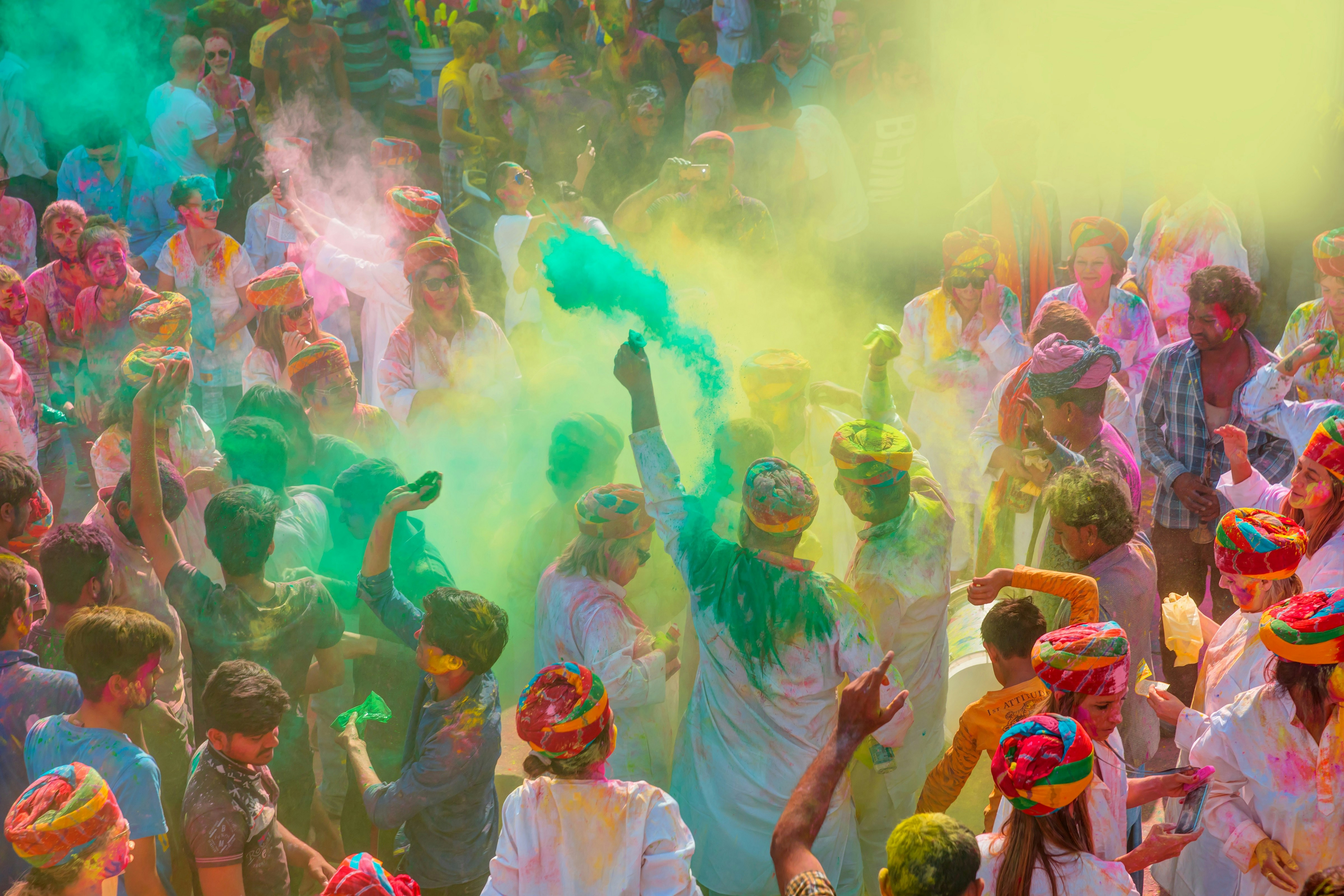 A group of tourists and locals throw around handfuls of colourful powder during Holi celebrations in Udaipur, India.