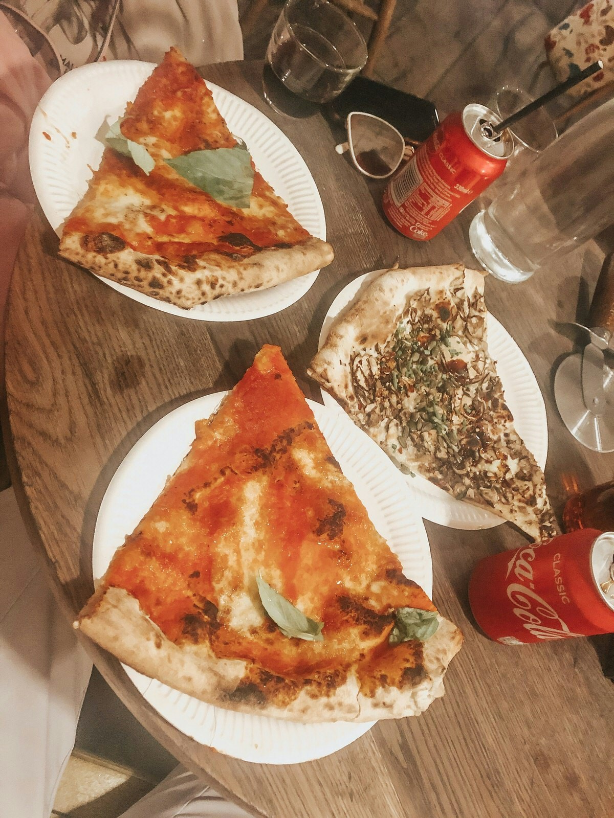 Tre stora skivor pizza på ett träbord på Homeslice restaurang 