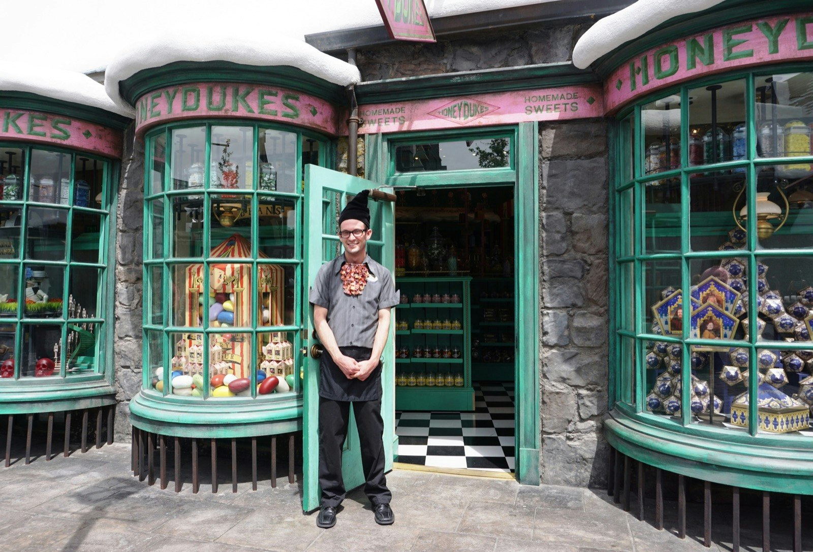 A costumed attendant stands in front of a store called Honey Dukes at the Wizarding World of Harry Potter