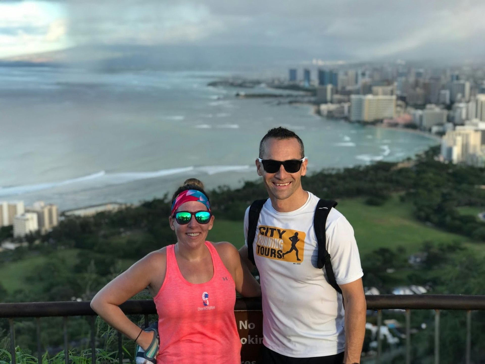 A woman and her sightrunning guide pose for a photo at the top of Diamond Head crater in Honolulu