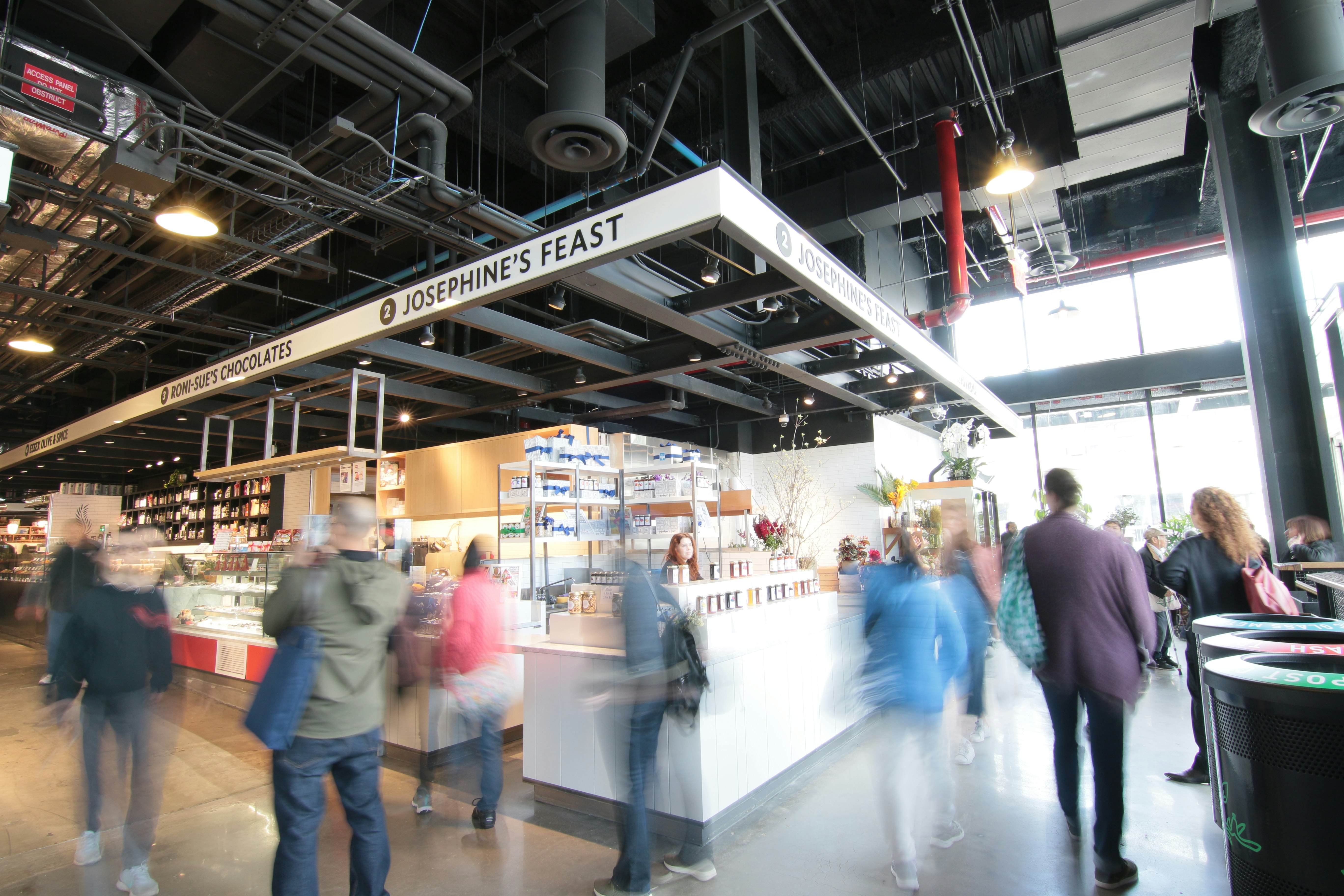 A long exposure of people milling around inside a food hall