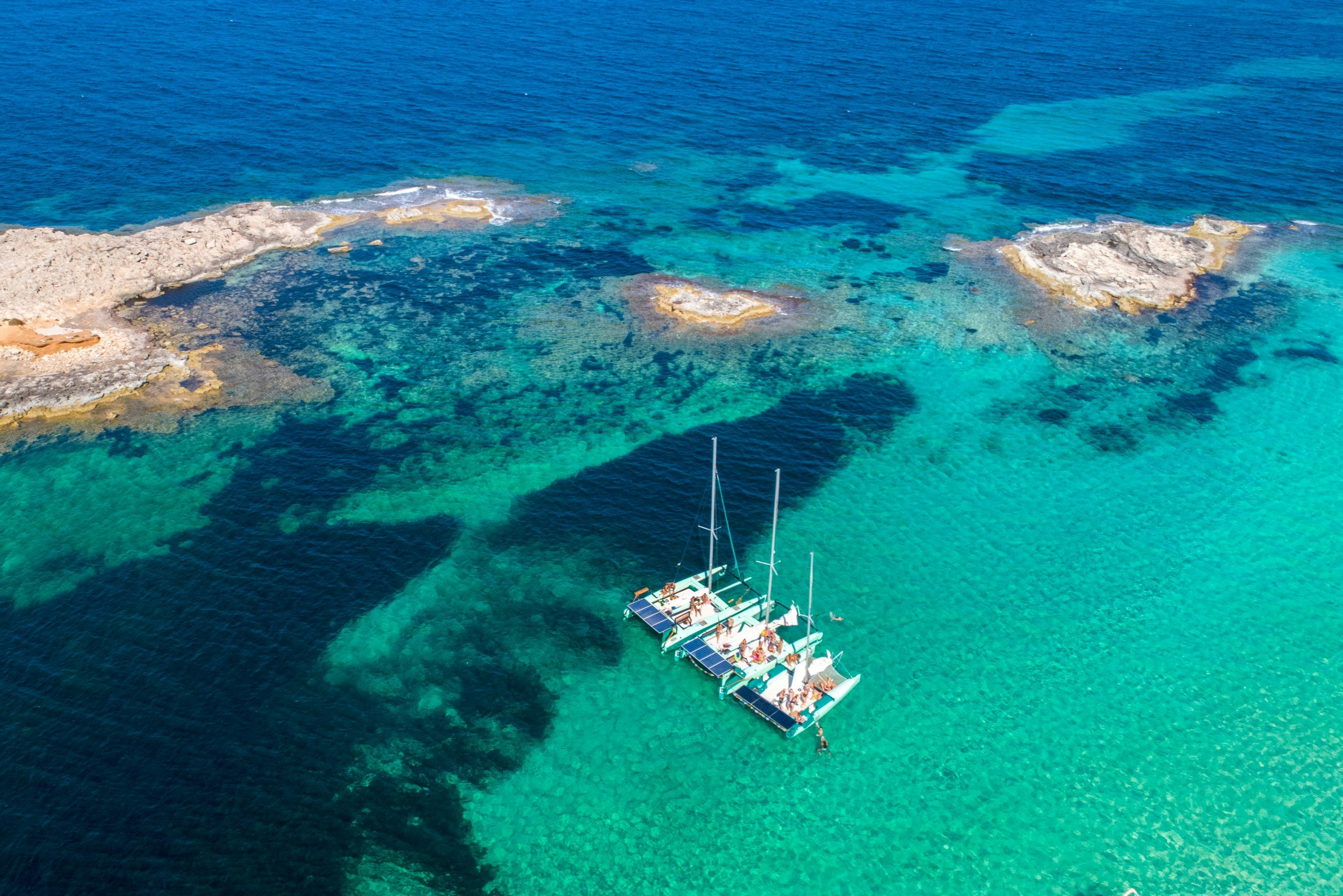 An aerial view of three eco boats in Ibiza in the sea