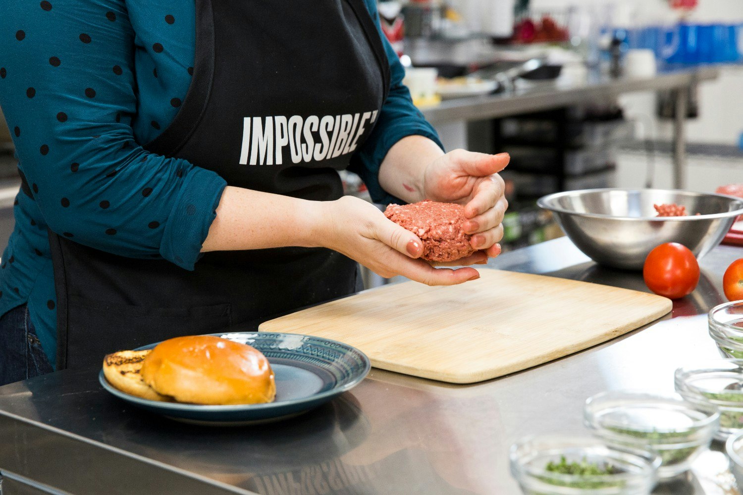 A woman preparing burger patties