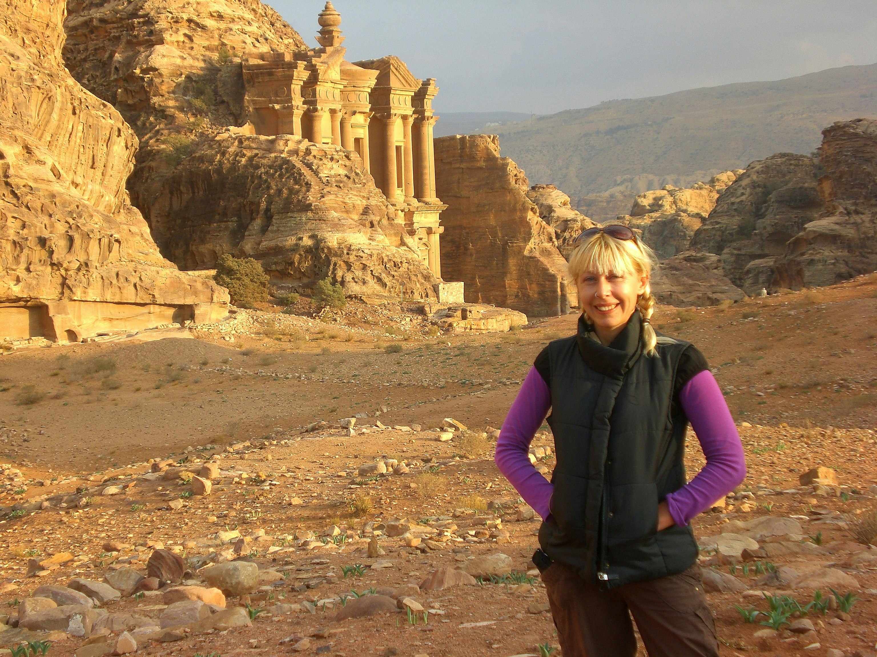 Jess poses for the camera with one of the elaborate, sandstone-carved facades of the ancient city of of Petra behind her.