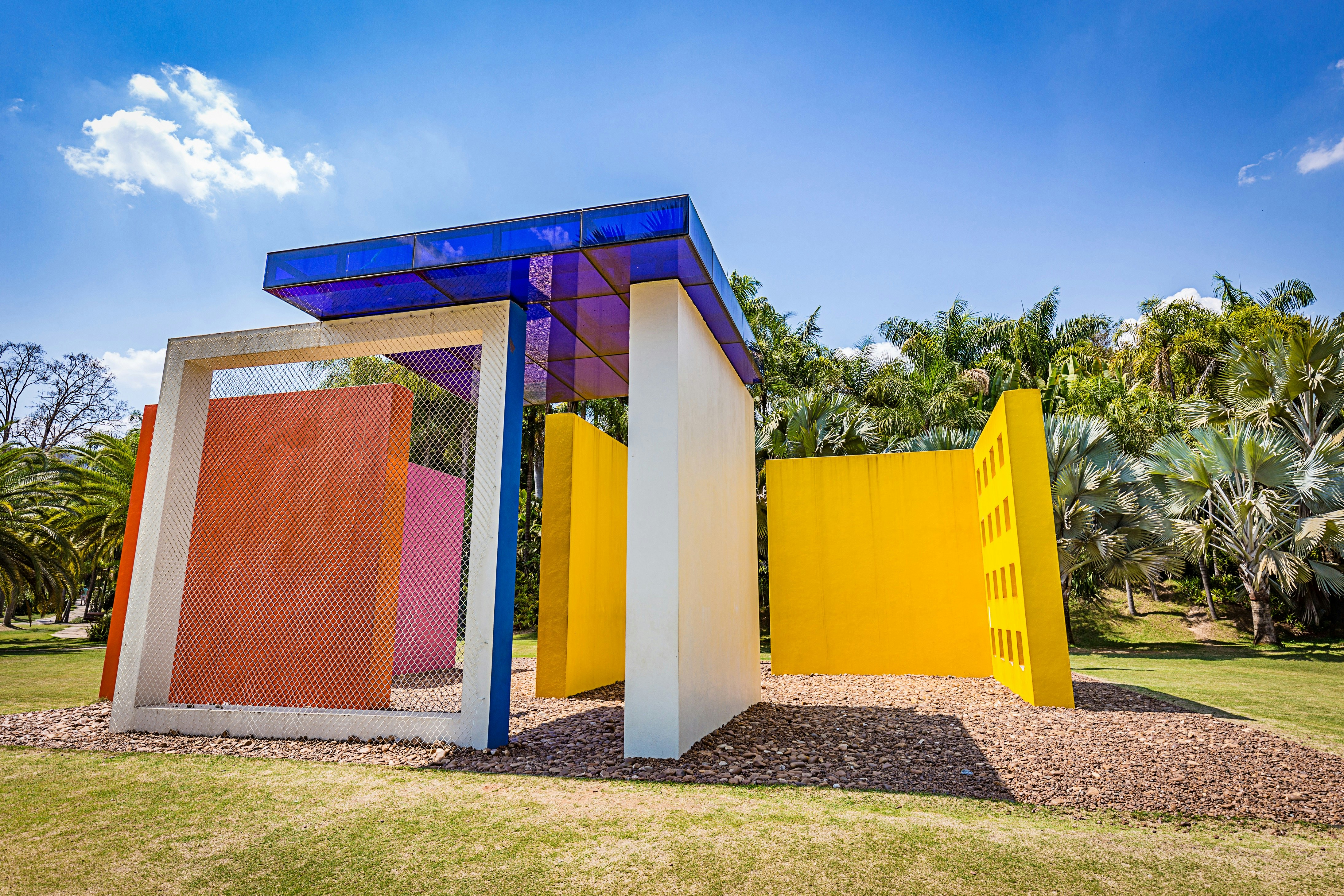 One of the works at huge open-air art museum Instituto de Arte Contemporânea Inhotim; it consists of different-coloured squares of concrete and glass, with tropical trees and plants behind it. 