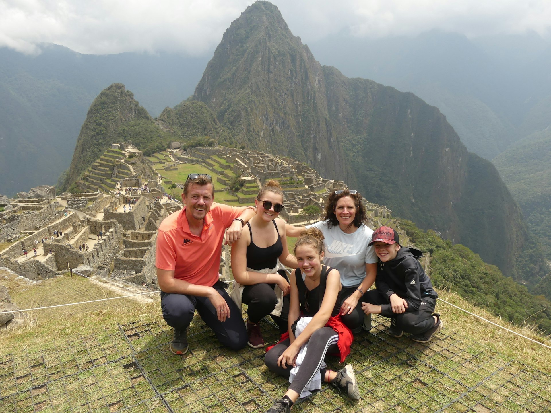 A family poses at the summit of Machu Pichu