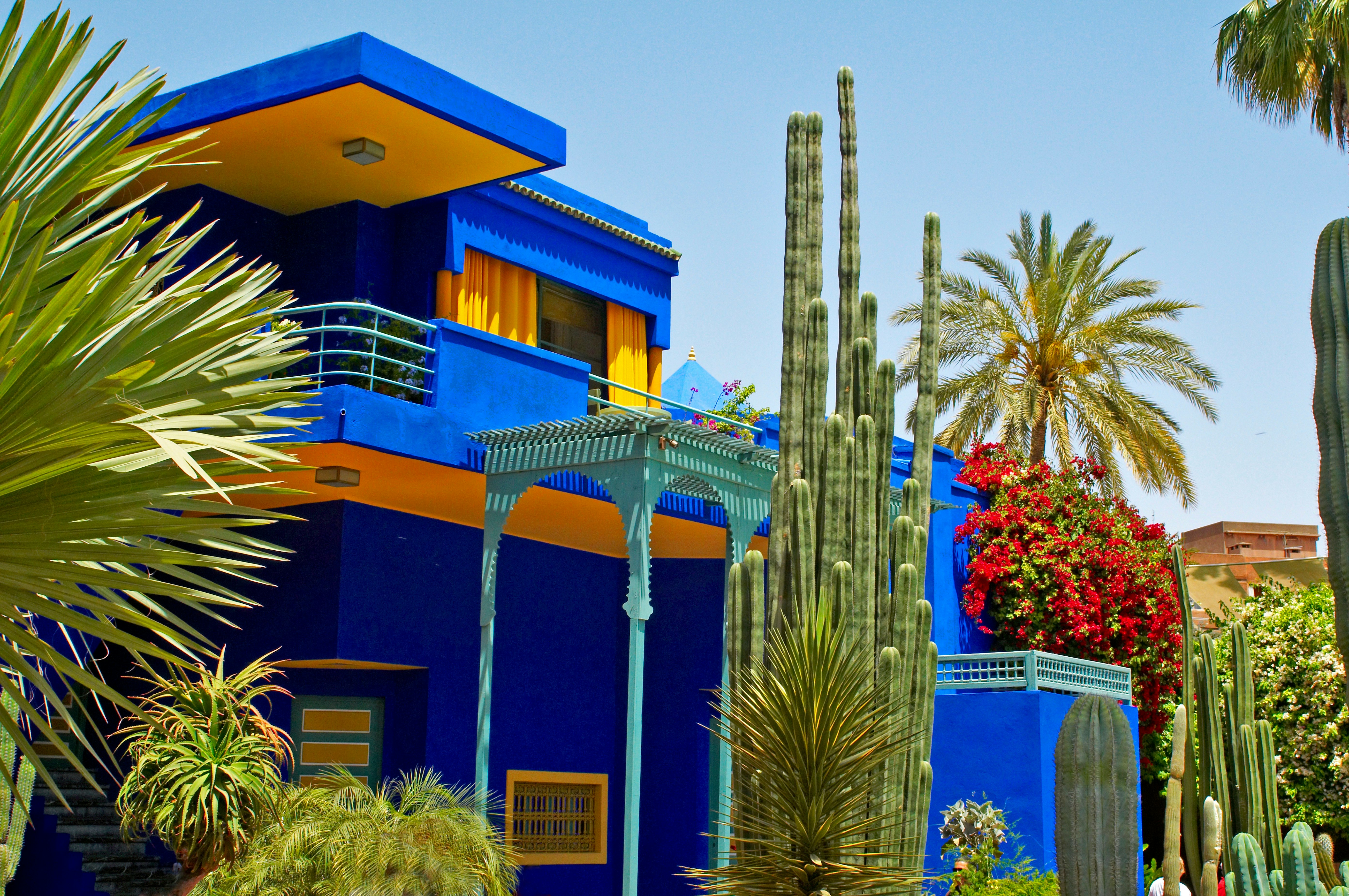 Colourful modern exterior of the Jardin Majorelle museum building with varied plants in the garden