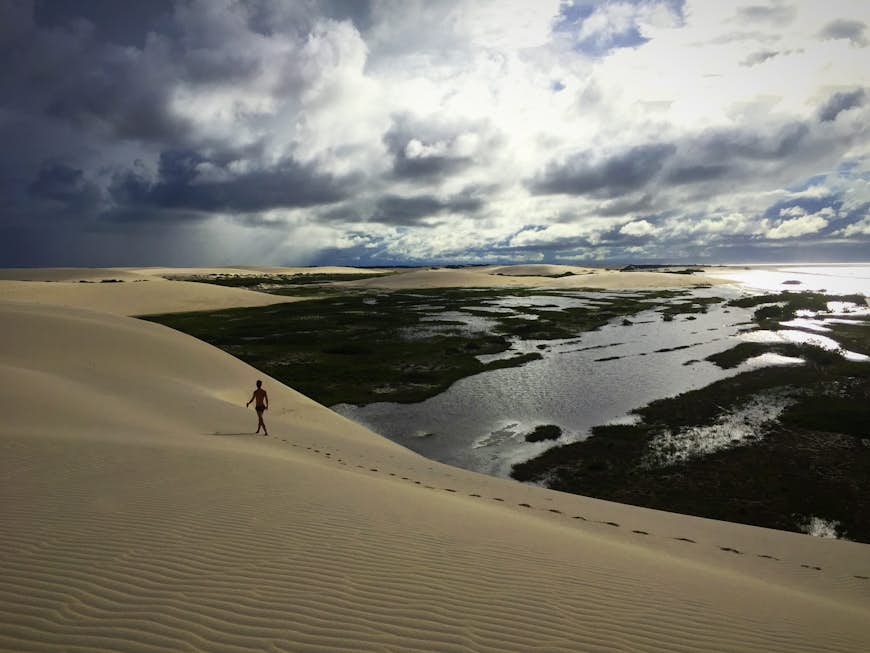 Person walking over a sand dune in Jericoacoara, Brazil