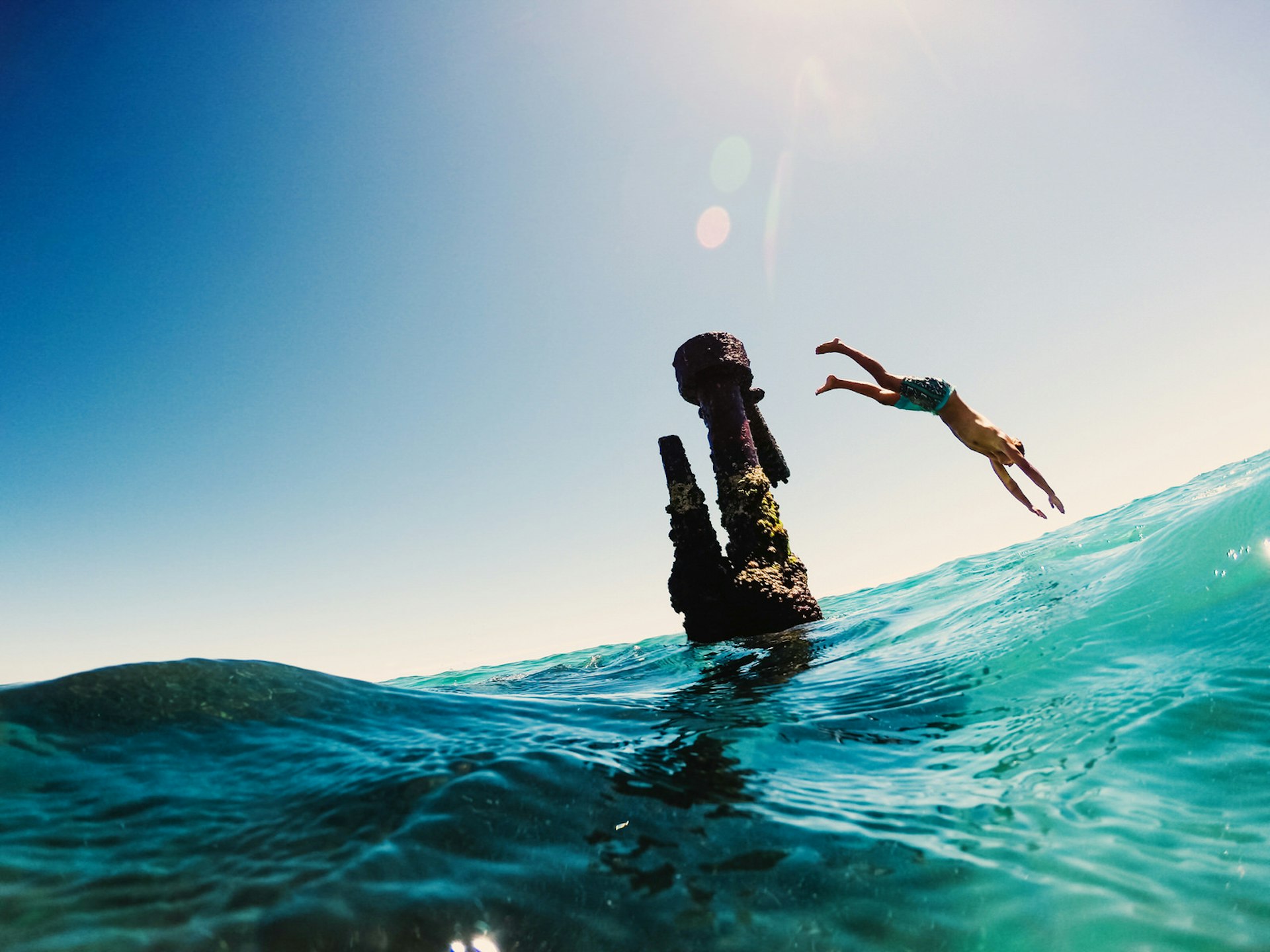 Man diving from wreck into sea, Byron Bay, Australia