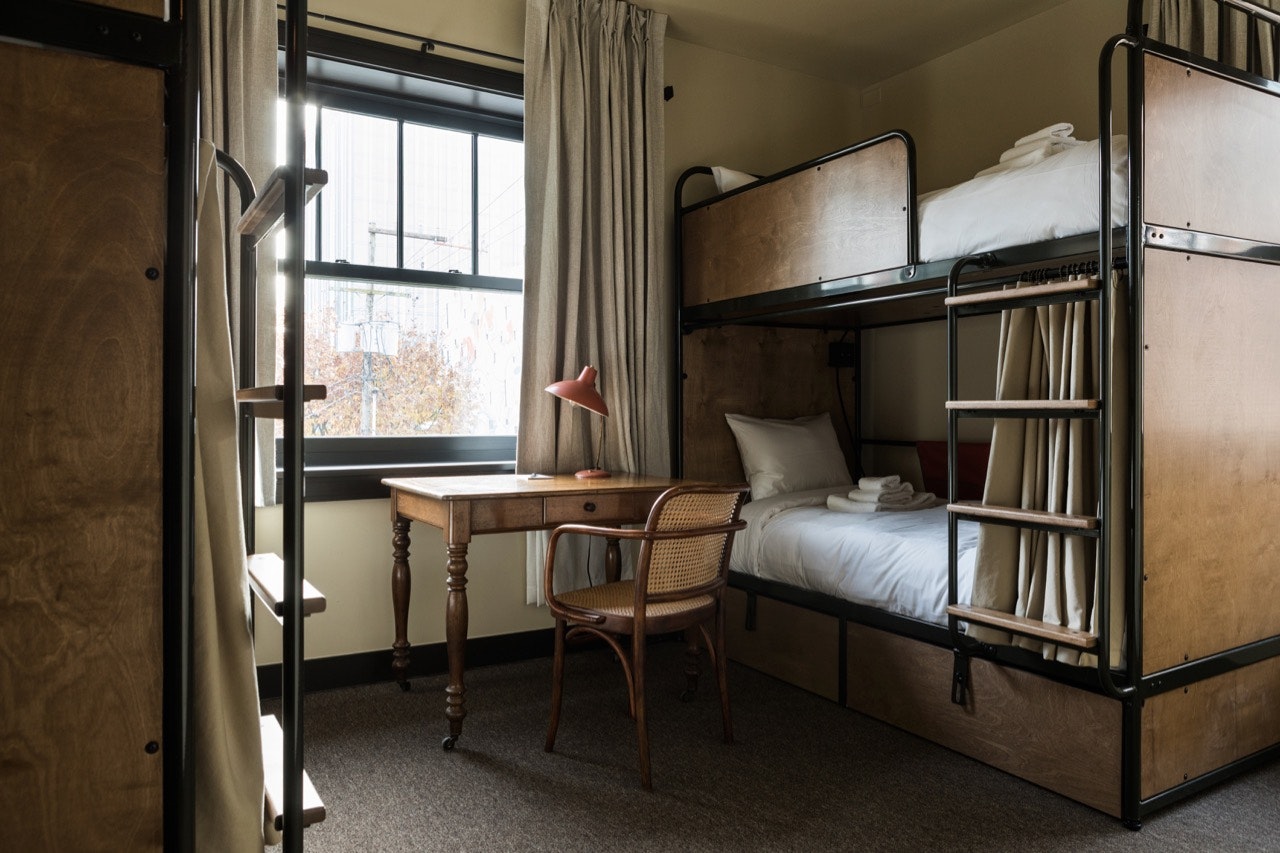 A shared room with a bunk bed and a desk at KEX Portland. 
