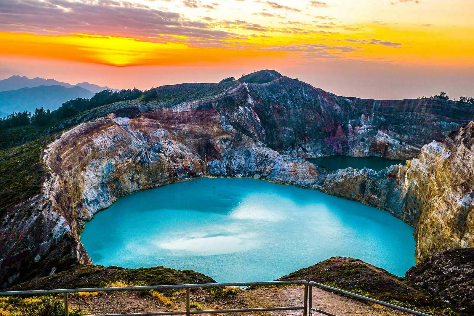 A turquoise crater lake sits on the top of the volcano Kelimutu at sunset. East Nusa Tenggara, Indonesia.