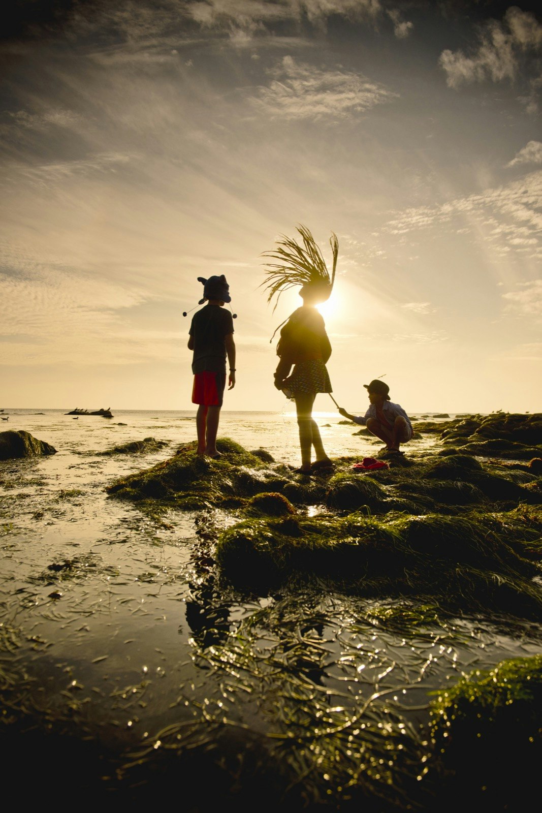 Kids jumping around at sunset in the tide pools in La Jolla, California