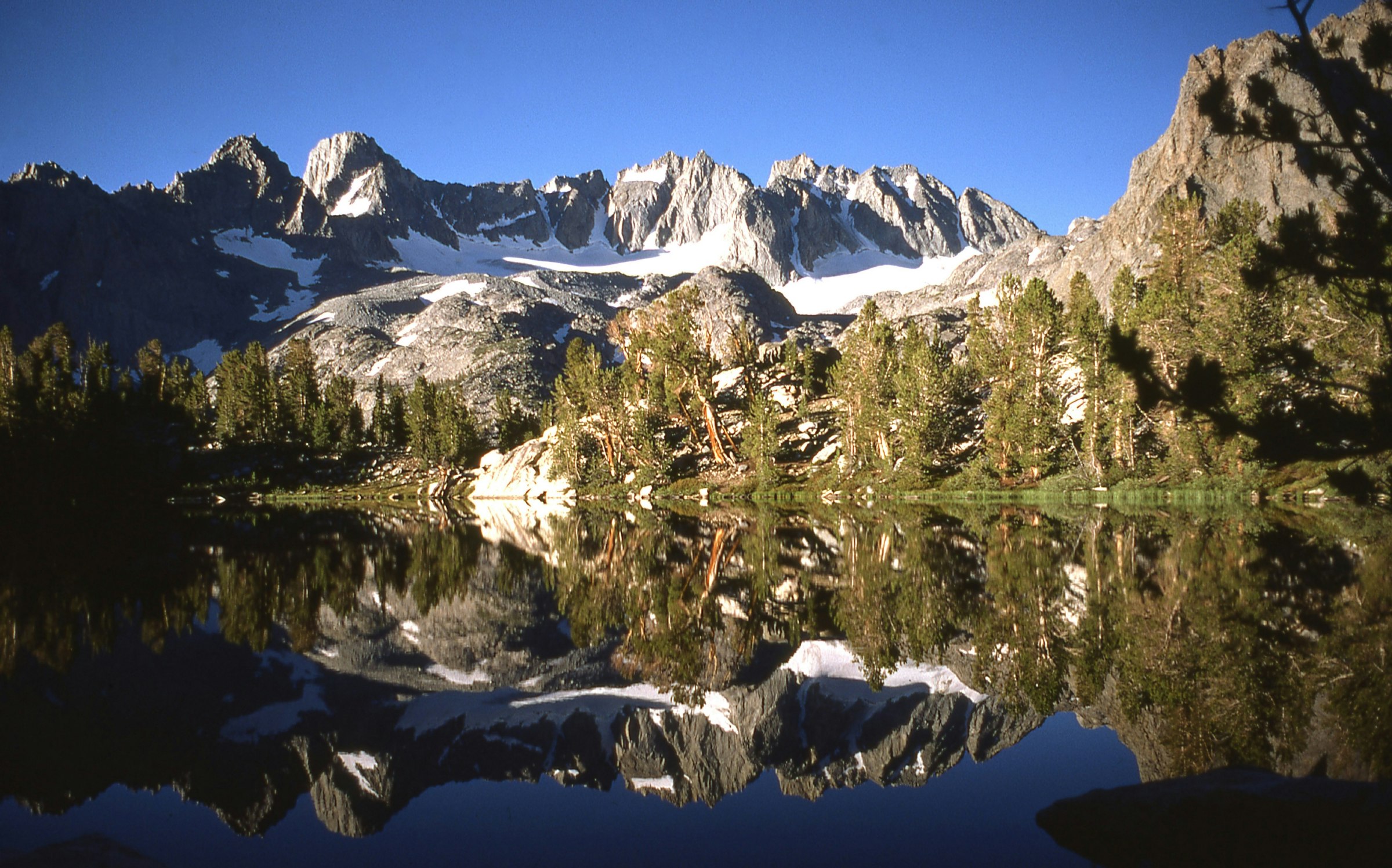 A glacial lake surrounded by snow capped mountains in King's Canyon, California