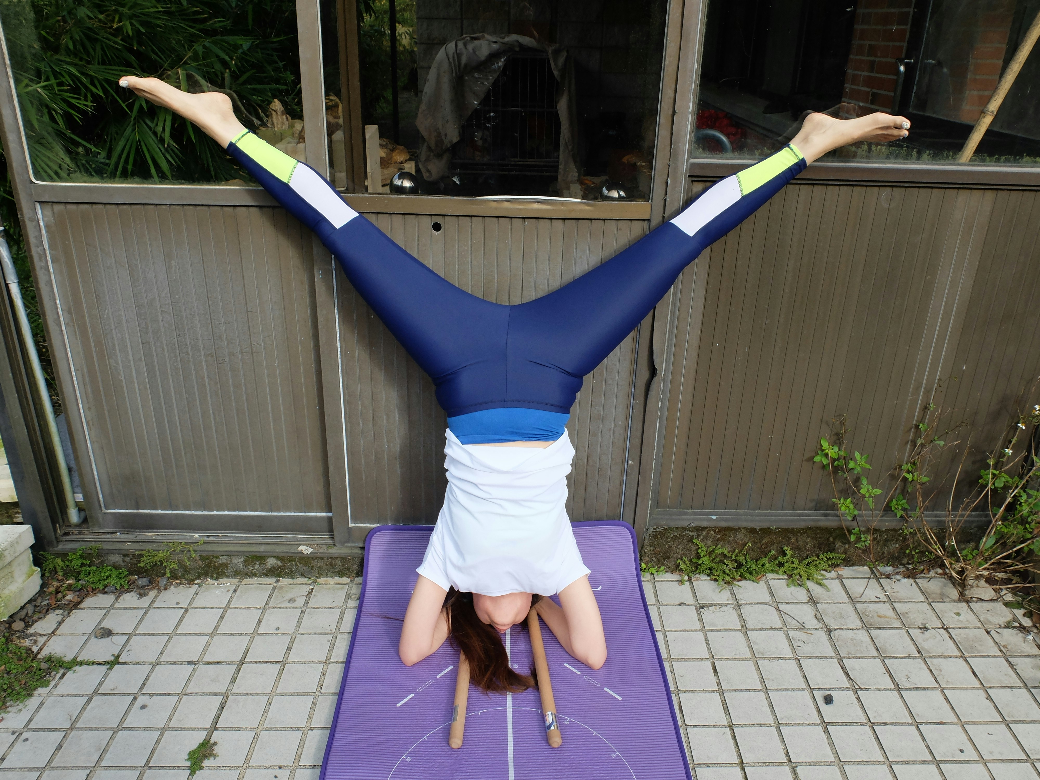 Hsiao Mei-Fang performs an acrobatic headstand on a purple mat, before beginning the massage.