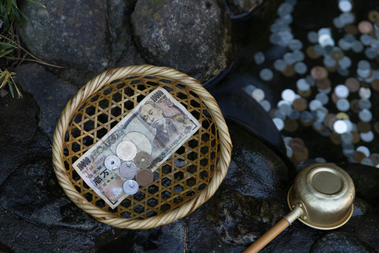 Money at the Zeniarai Benten Shrine in Japan; it is said money that is washed in the water here will double
