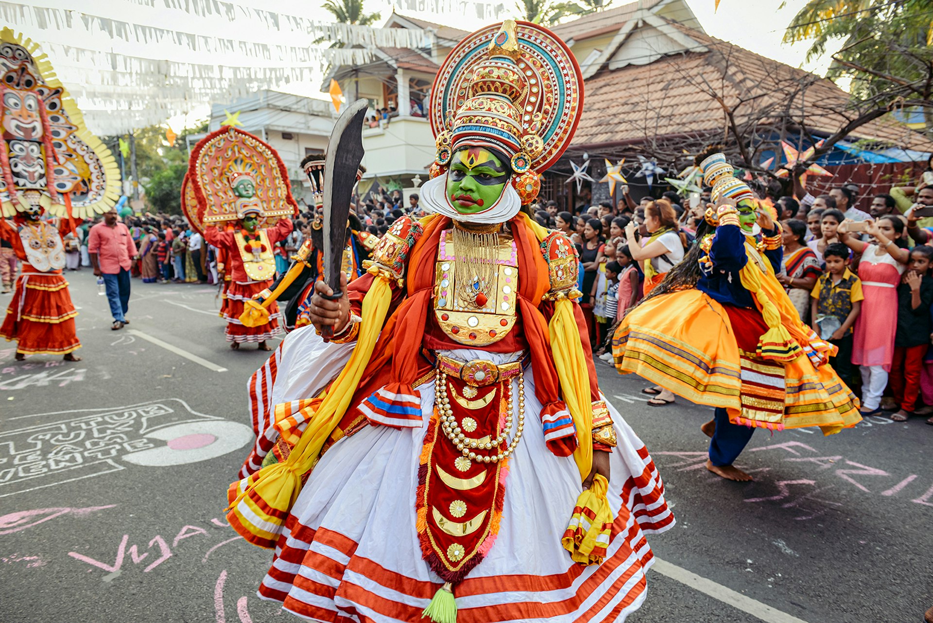 Heavily costumed Kathakali performers walk the streets of Fort Kochin. Kochi, India.
