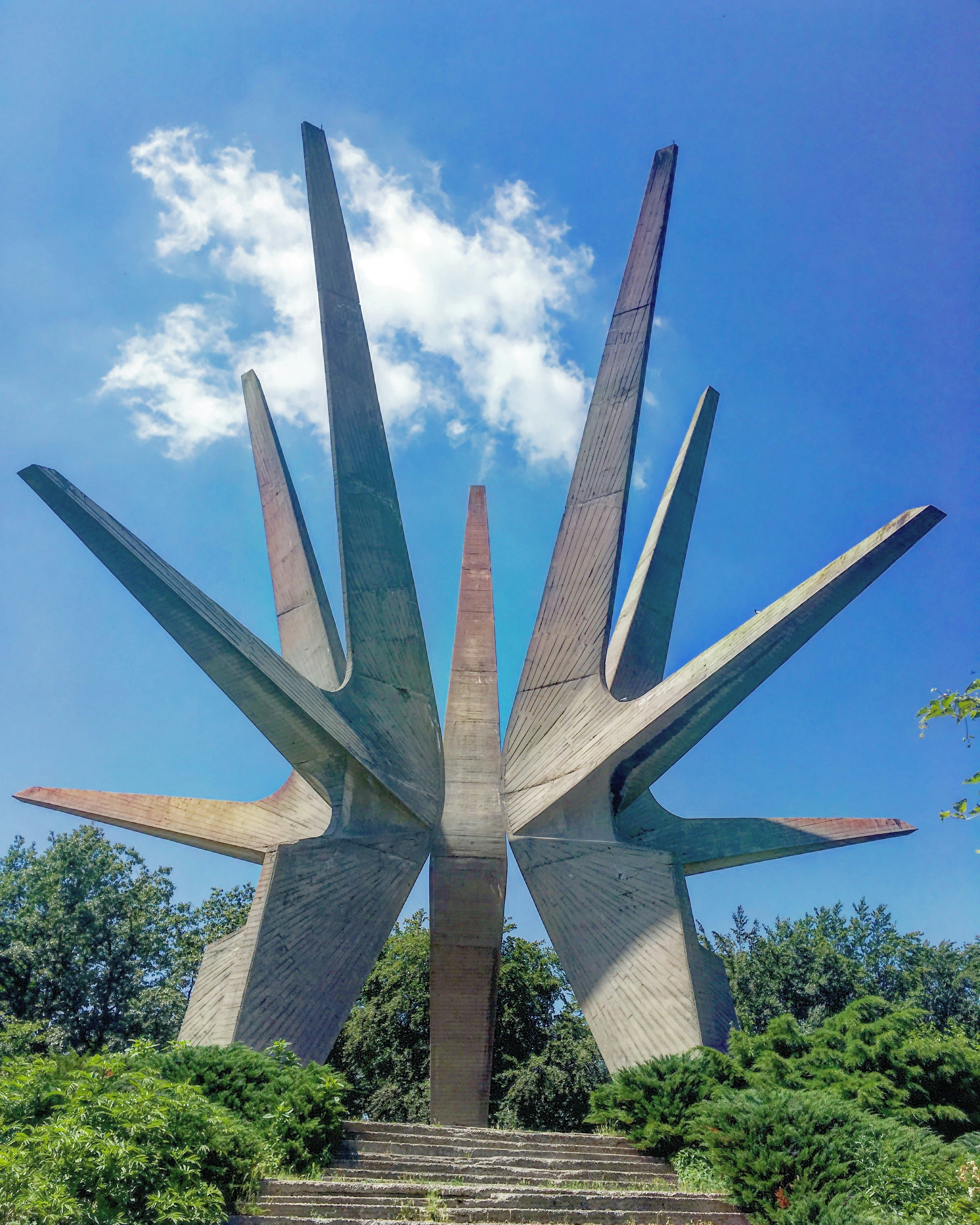 A large concrete structure branches out into a three-dimensional star shape against a blue sky.