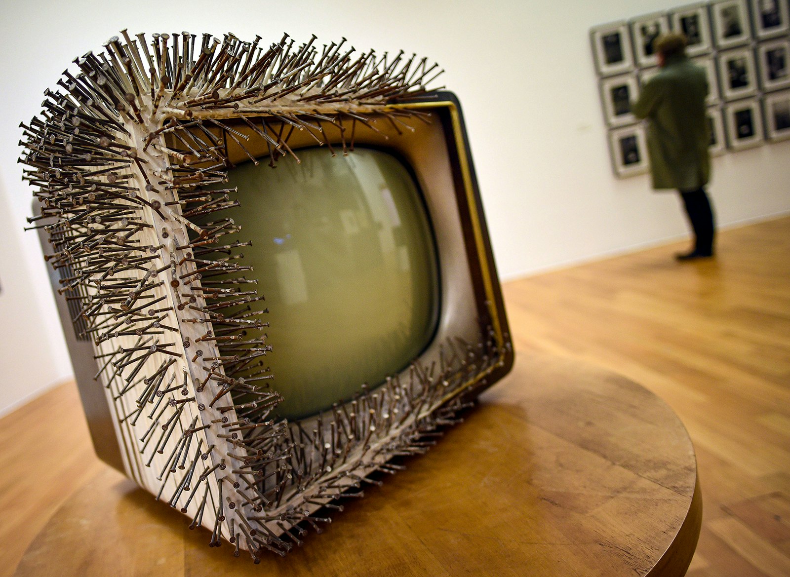 A box television with a cluster of needles sticking out of the top, bottom, and left side.