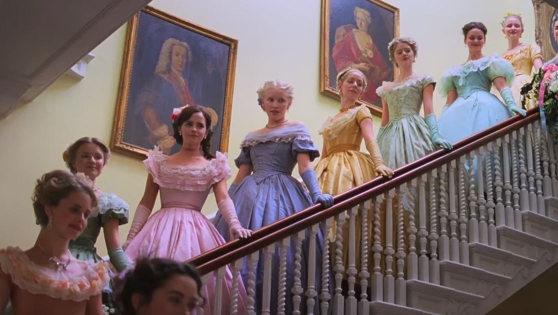A line of young women in colourful dresses descending a staircase