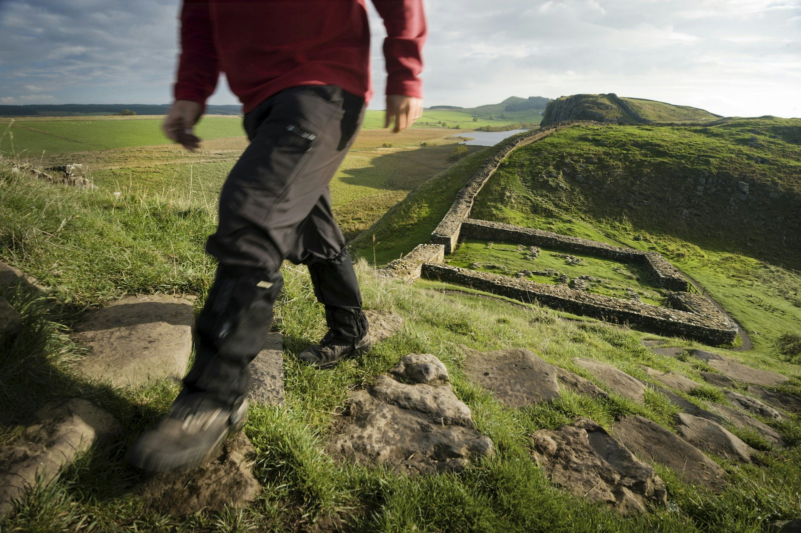 Hiker walking Hadrian's Wall trail at Milecastle 39, also known as Castle Nick.
