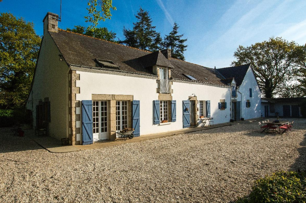 Exterior shot of a white and blue French farmhouse