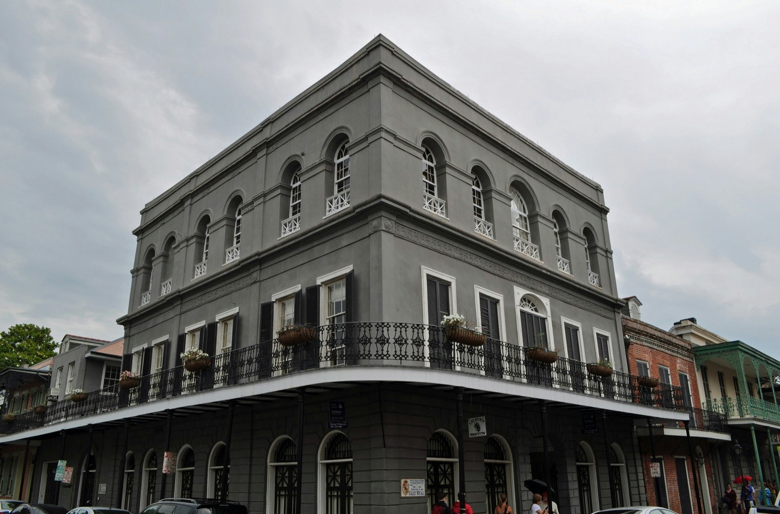 External shot of the slate gray LaLaurie Mansion with its metal railings lined with flowers; haunted places world