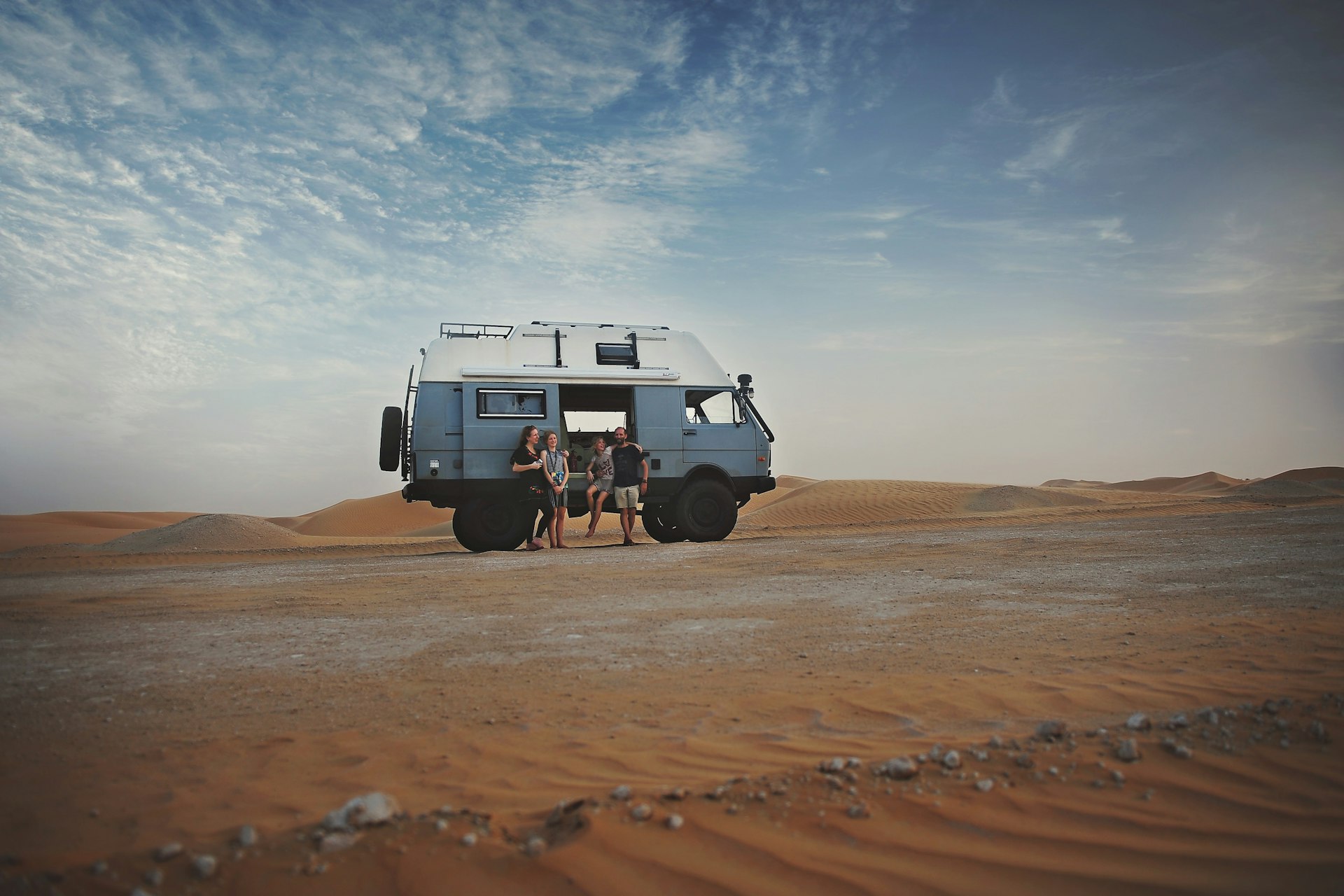 The Larmour family pose outside their van in the desert