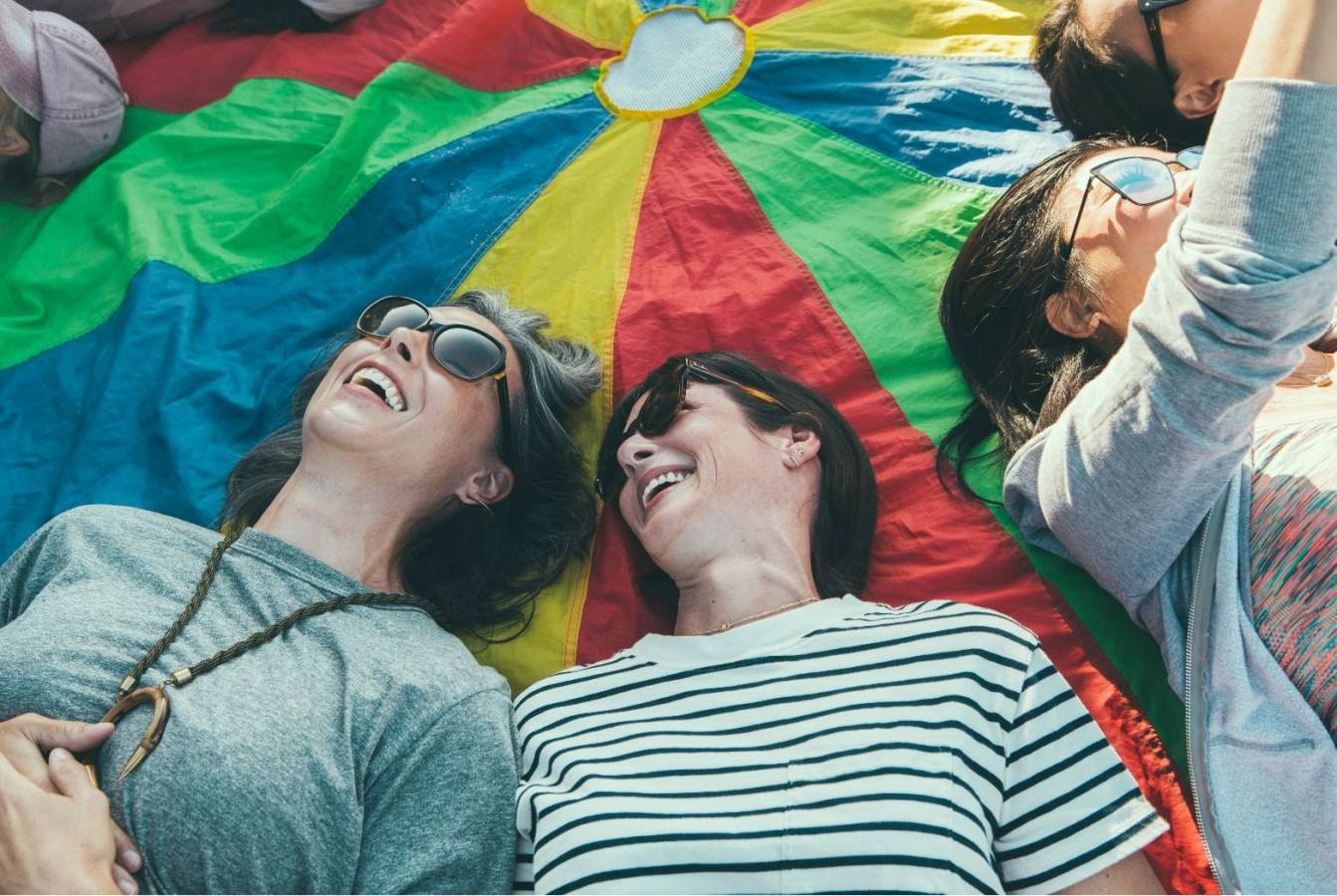 Two women lie on the floor laughing uncontrollably during a laughter yoga class in Laguna Beach, California.