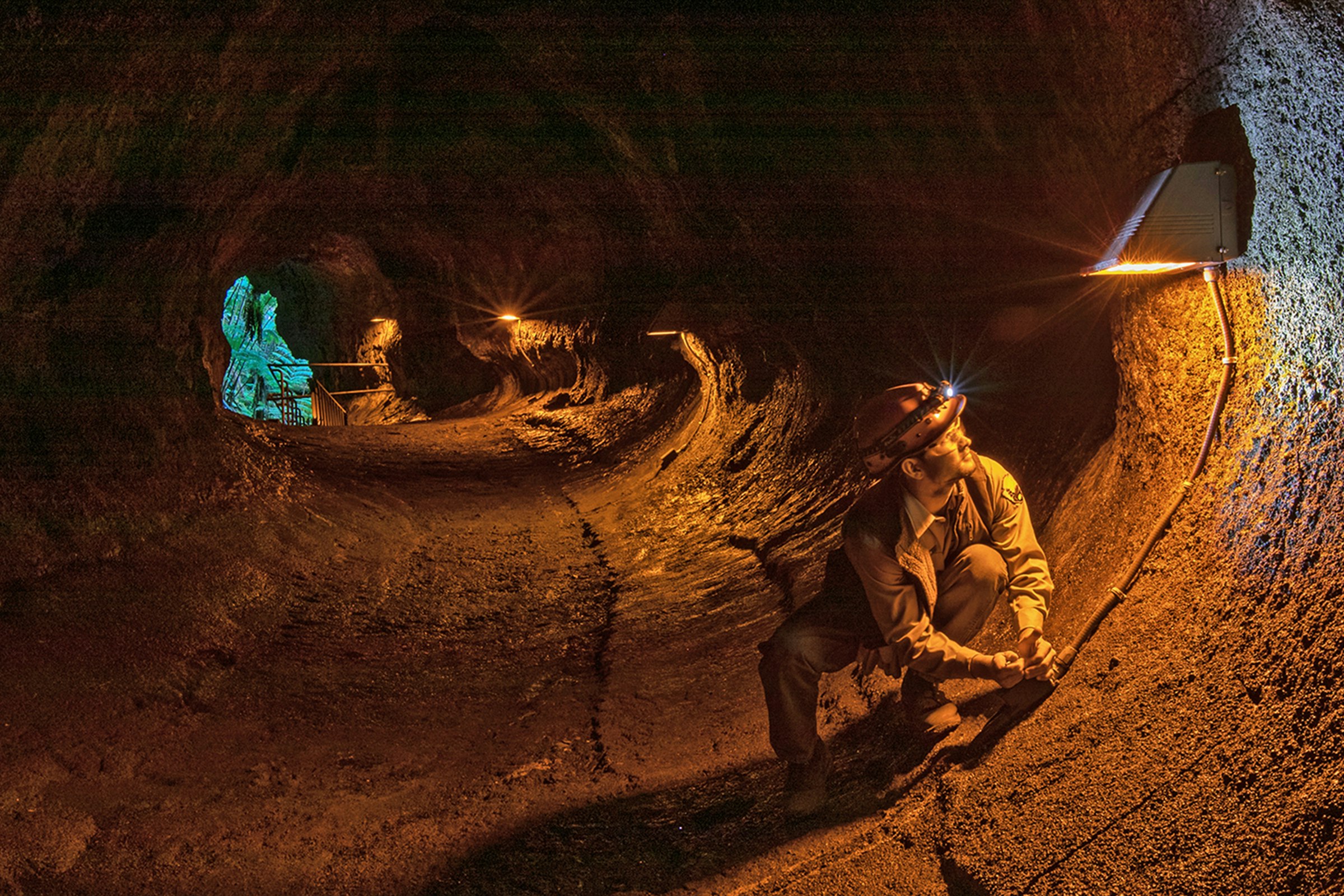 A worker replacing the electric line inside the lava tube.