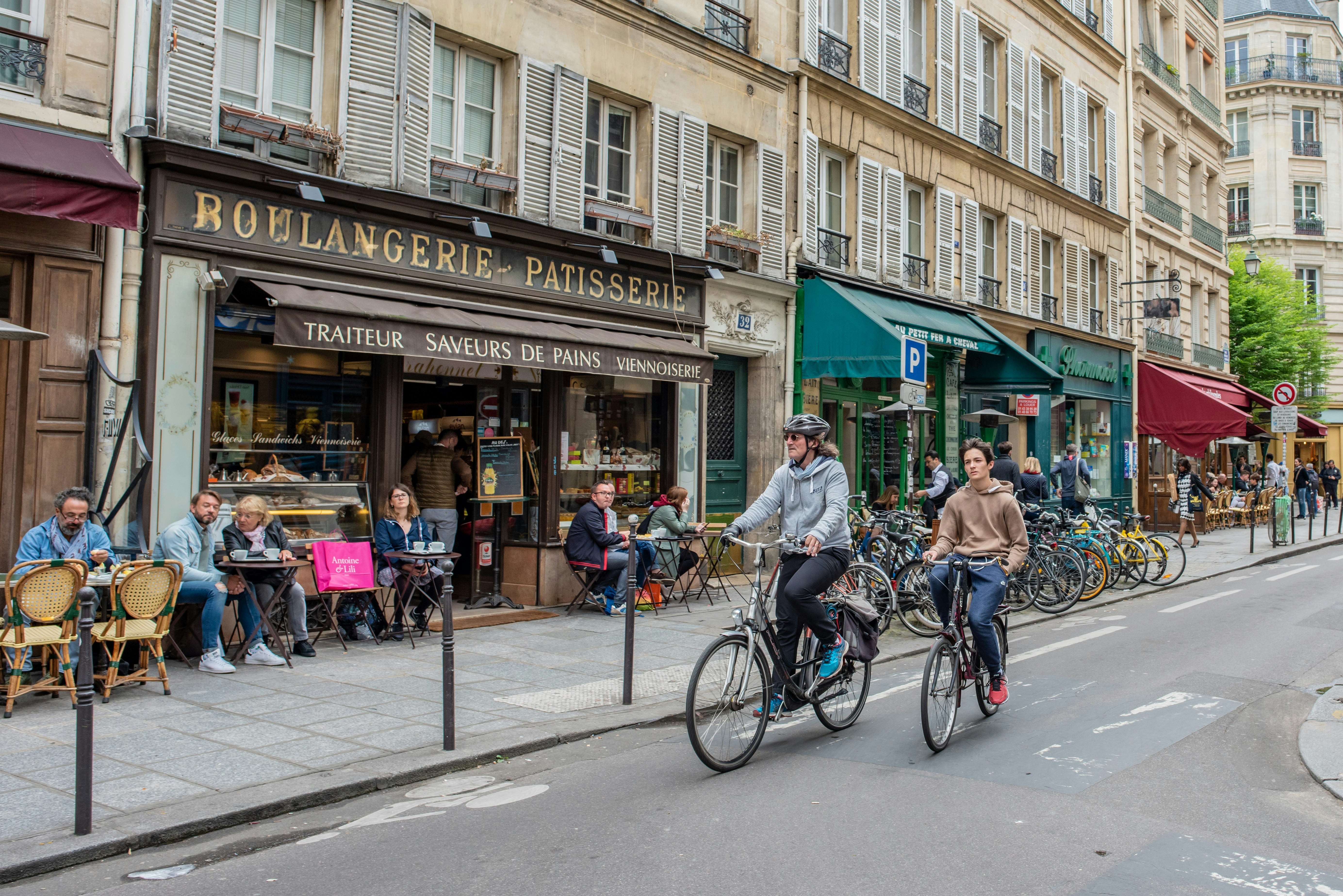 People ride bikes through the old Marais neighbourhood,