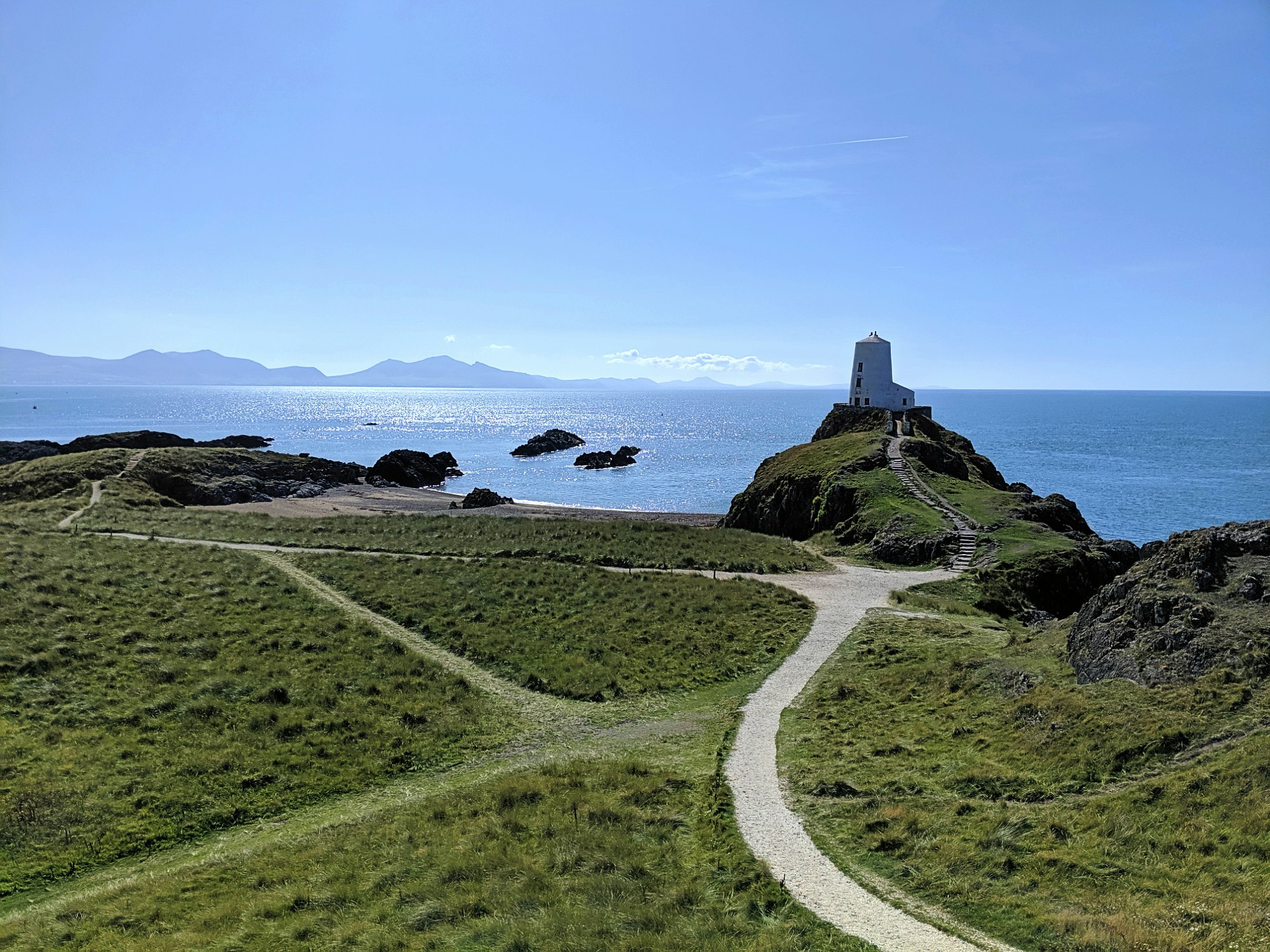 A view of the sea and the lighthouse on Llanddwyn Island. 