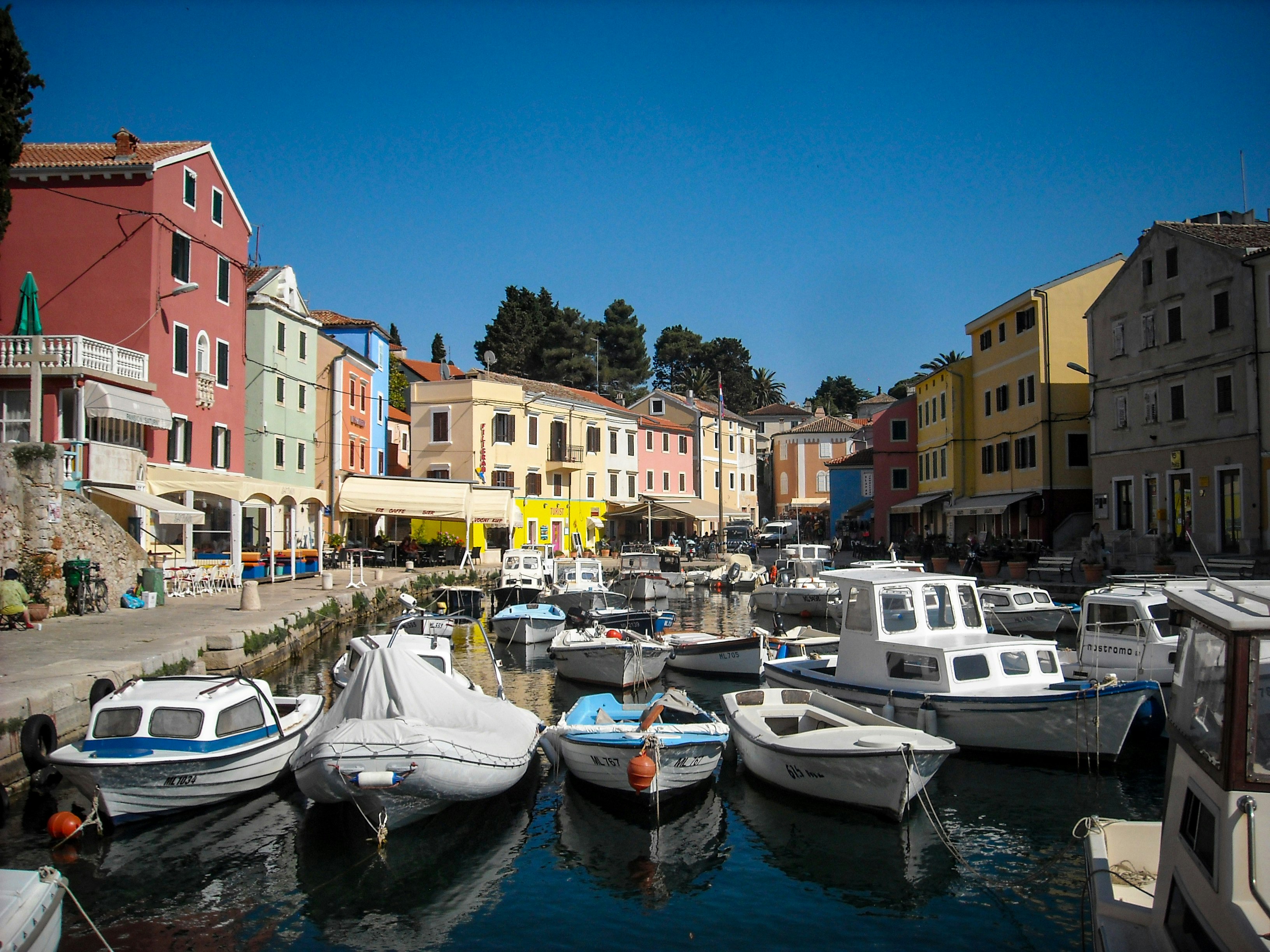 Pastel houses line the small, boat-filled harbor of Lošinj. Kvarner Gulf.