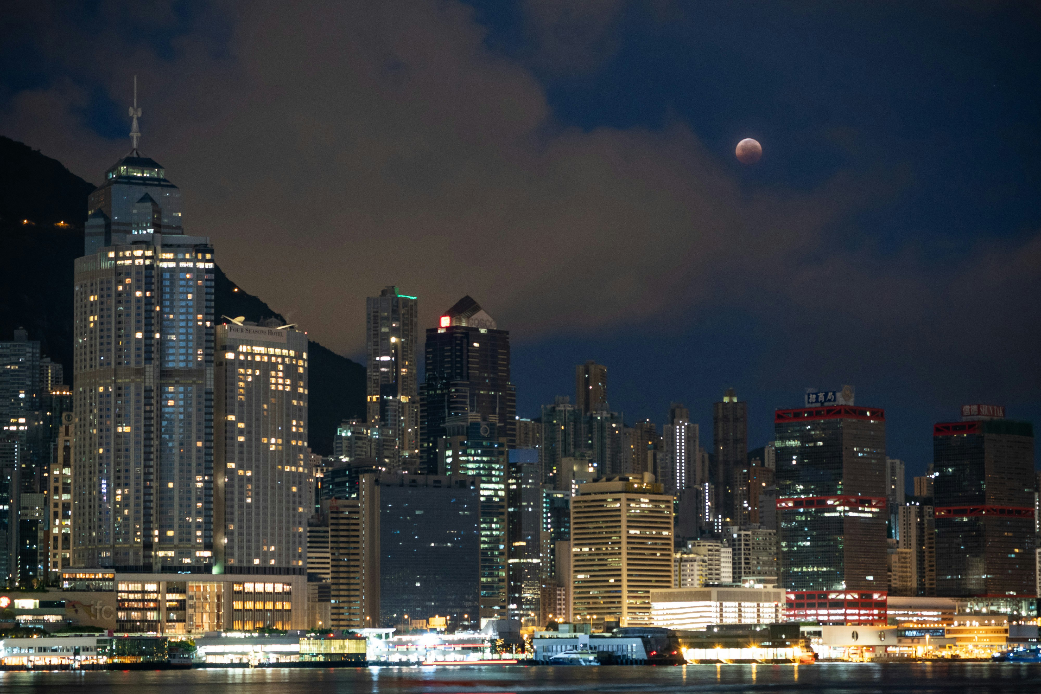 The lunar eclipse is seen above the skyscrapers in Hong Kong.