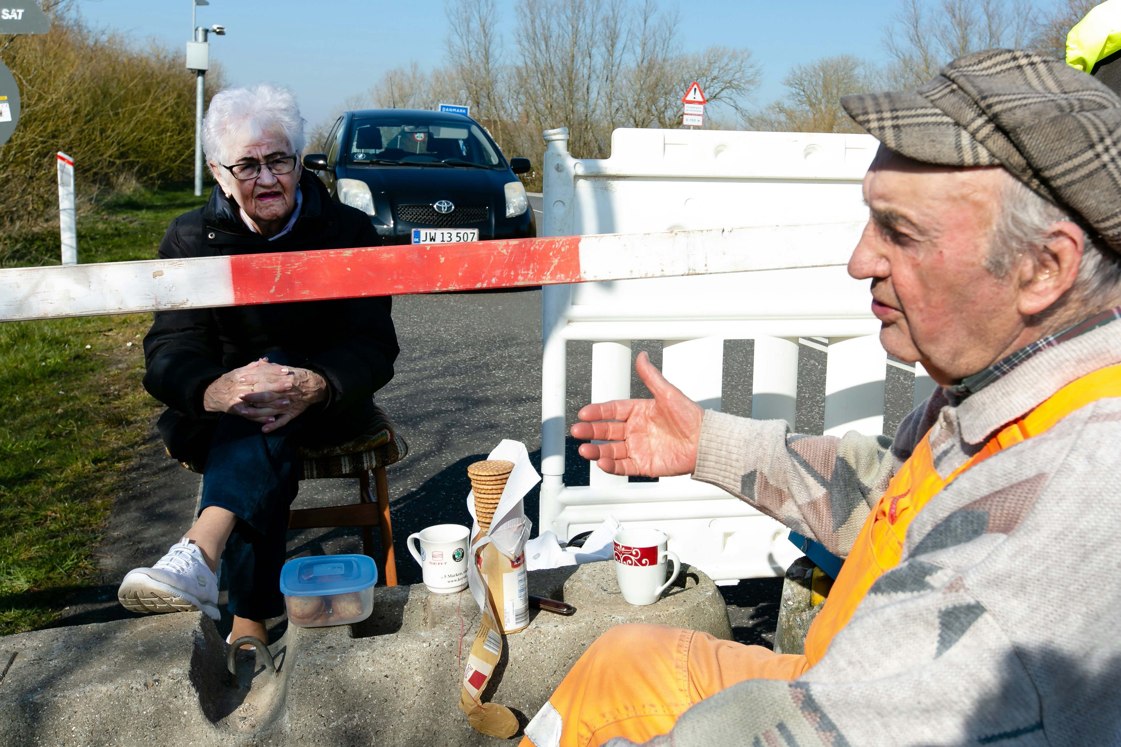 Karsten Tüchsen Hansen (r) and the Danish Inga Rasmussen are sitting at the German-Danish border crossing share a packet of biscuits