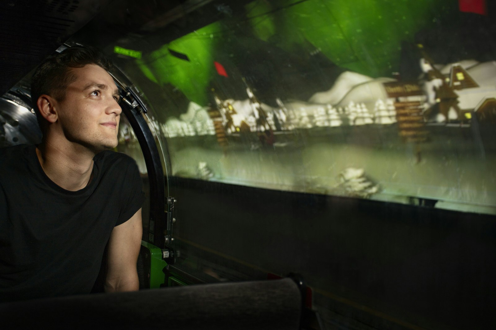 A man sits on the Mail Rail, looking at Christmas projections on the tunnel walls