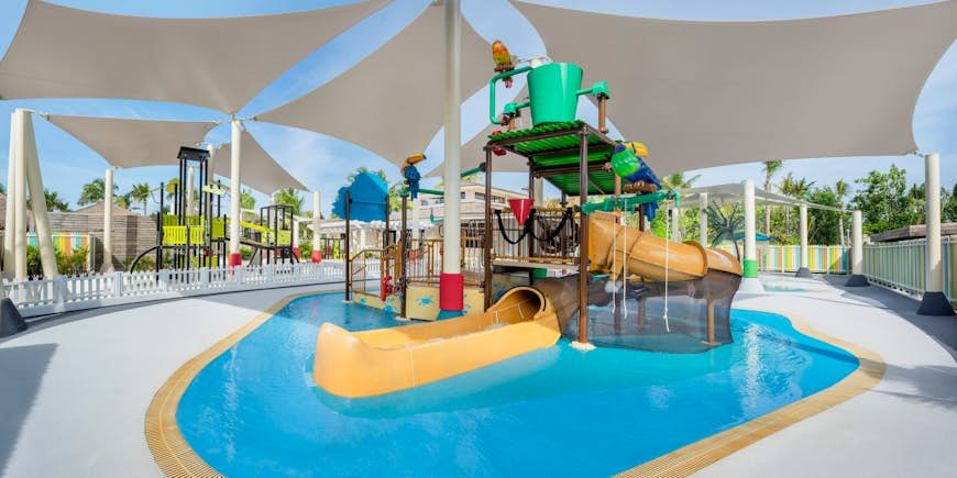 A waterslide in the pool area of the kids club at the Waldorf Astoria Maldives Ithaafushi resort.