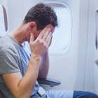Man holding his head on the plane.jpg