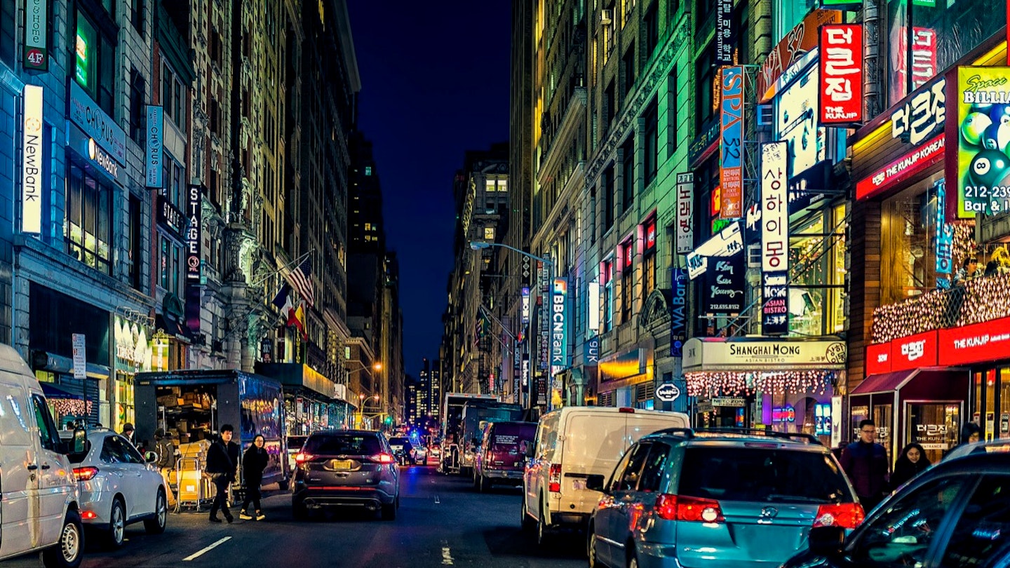 Manhattan's 32nd Street in Koreatown, the center of the thriving Korean business and entertainment community and district, at night with cars and bright lights