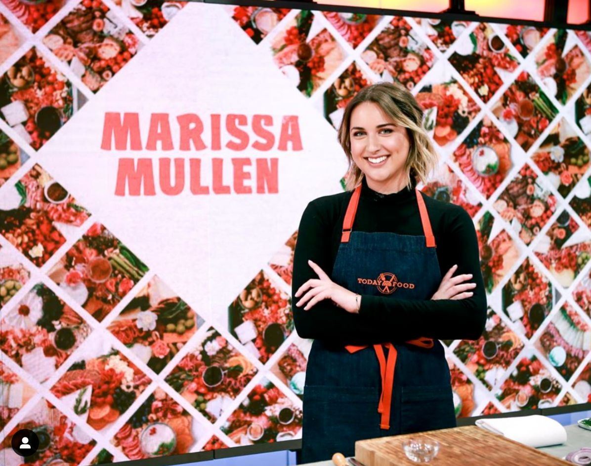 Marissa Mullen standng in front of a wall with her name on it