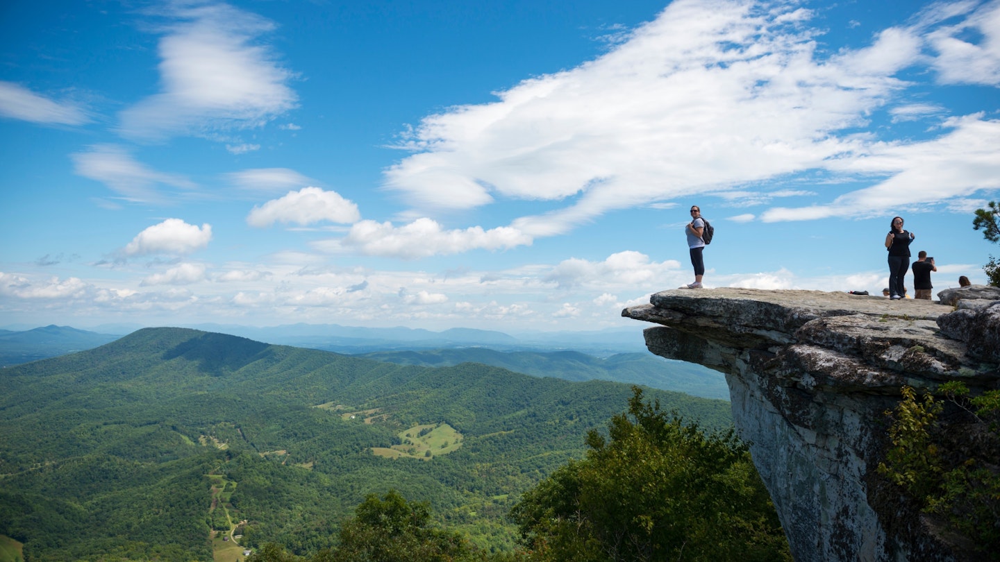 Hikers take in the view of the Appalachian Mountains from McAfee Knob on Catawba Mountain, Virginia 