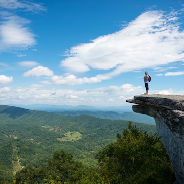 Hikers take in the view of the Appalachian Mountains from McAfee Knob on Catawba Mountain, Virginia