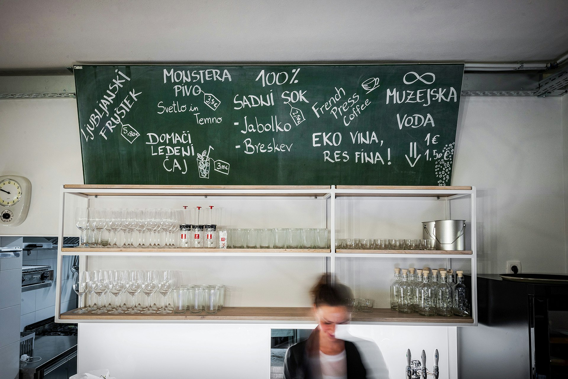 Inside Monstera bistro: a shelf of wineglasses lining the wall