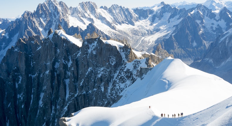 Mountaineers on Mont Blanc traversing a snowy ridge. 