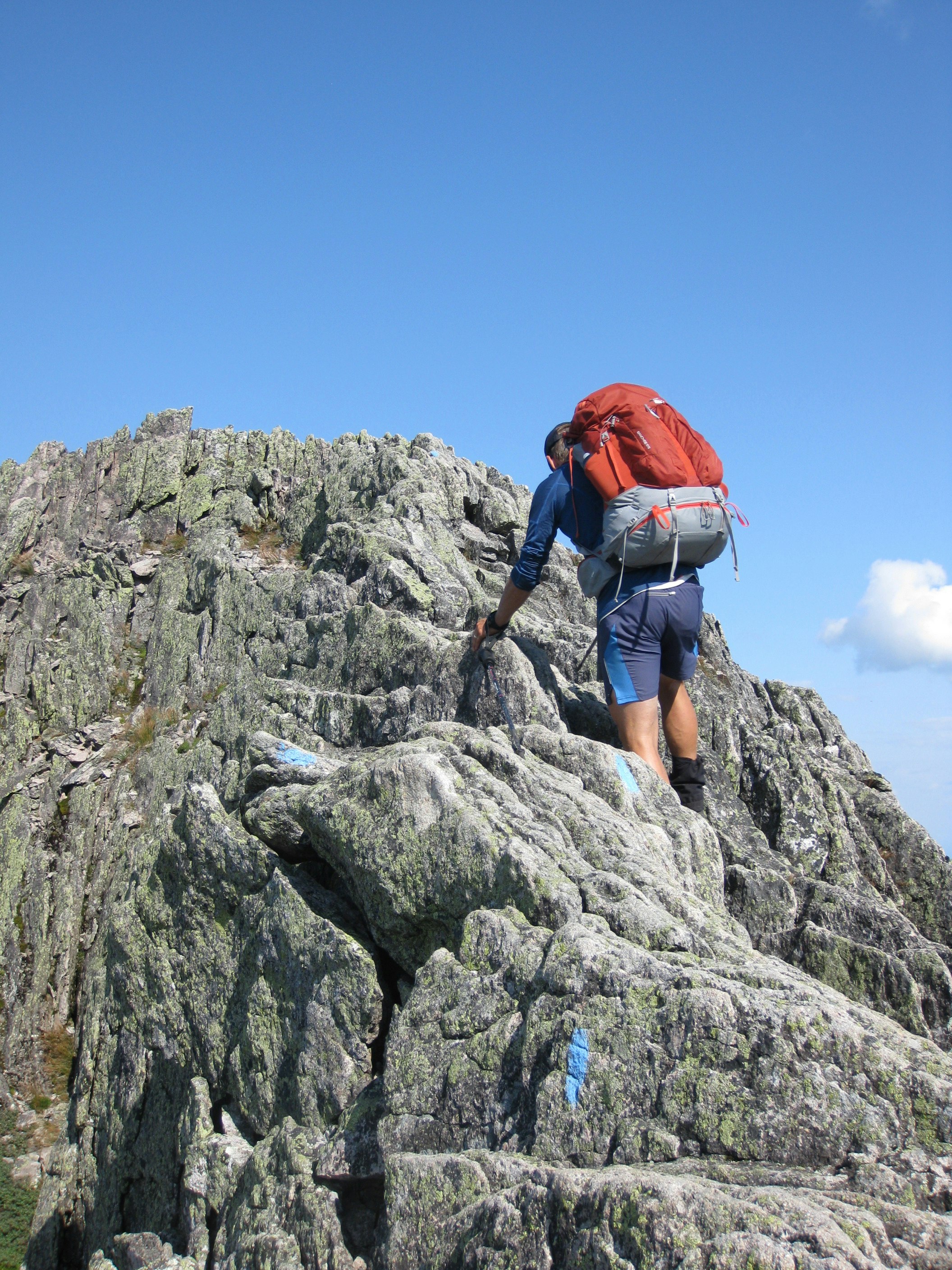 A man climbs down spiky rocks from the summit of Mount Katahdin in the Maine backwoods